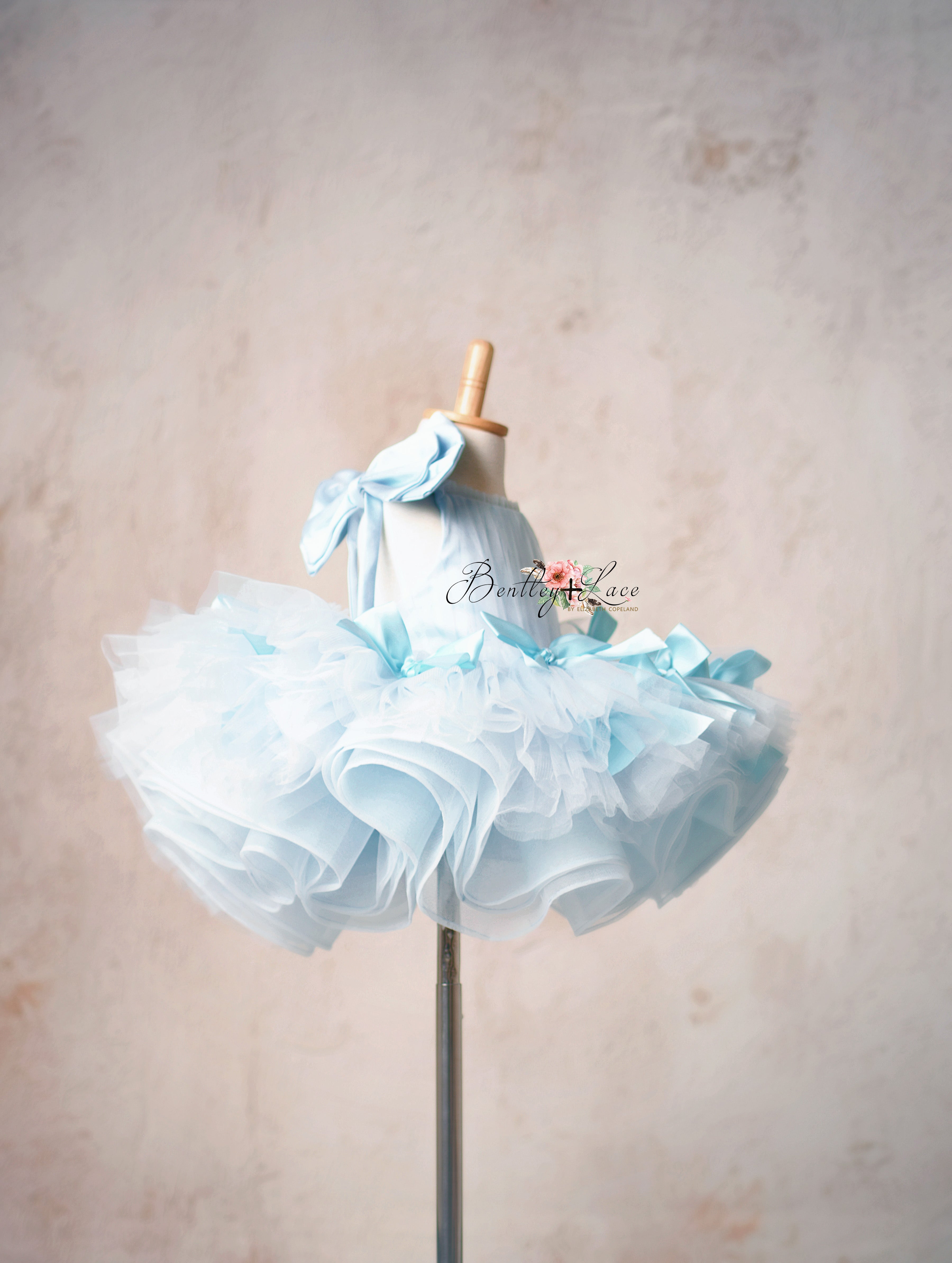 Graceful short gown with delicate bows and a dreamy tulle skirt.