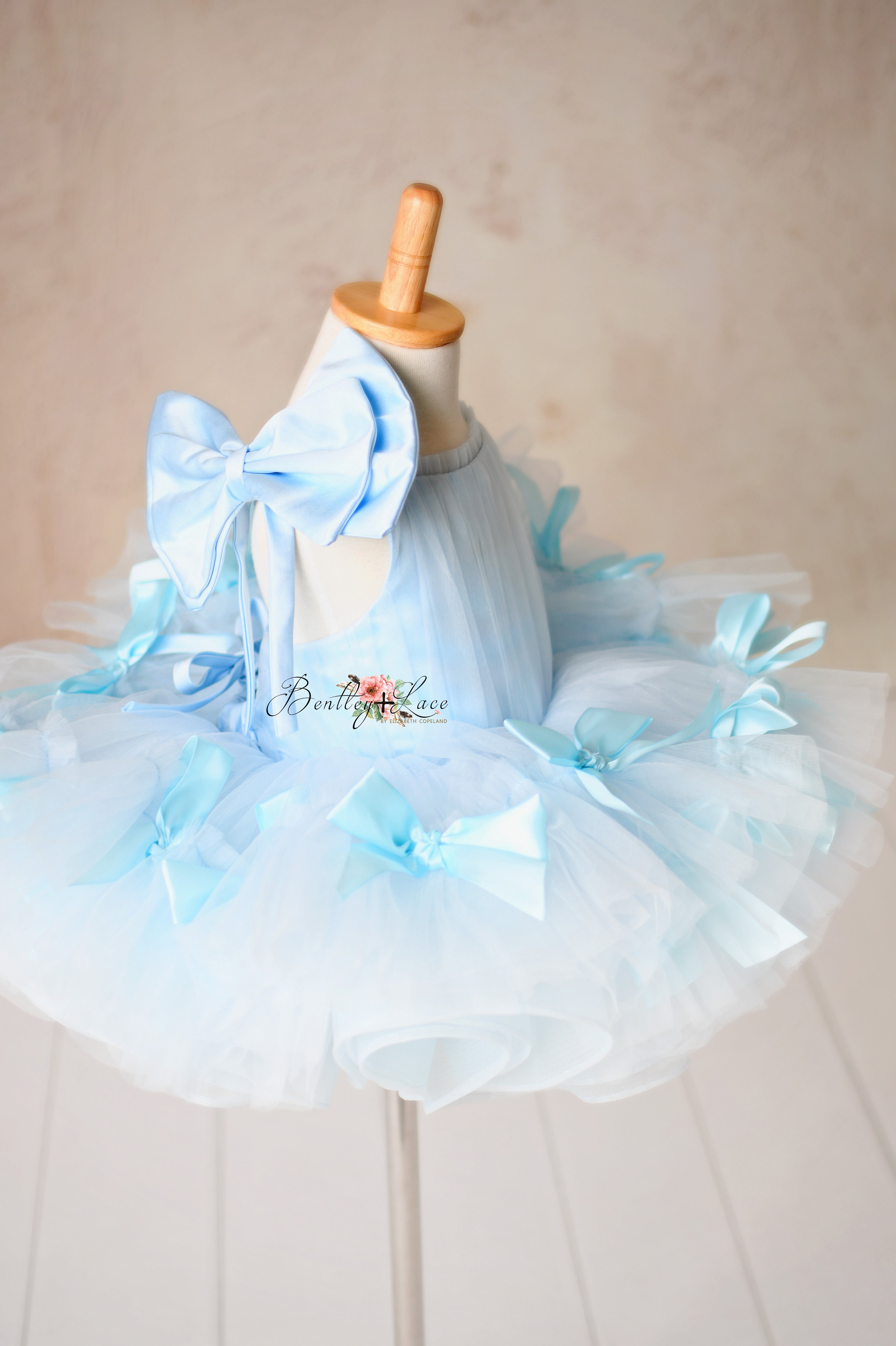 Handmade satin bows embellish this ethereal soft tulle dress.