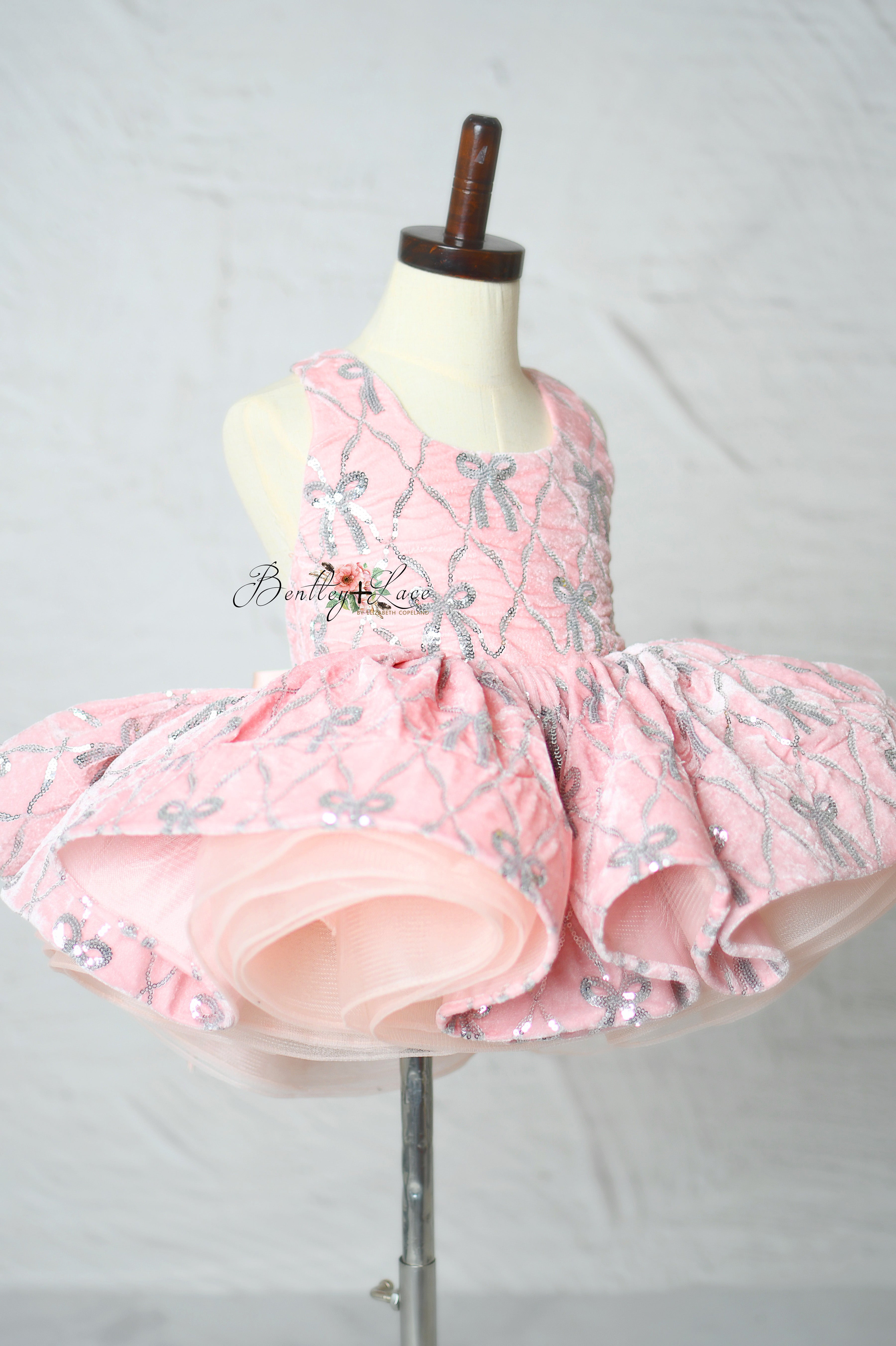 "Girls pink pageant dress with detailed bow embroidery"