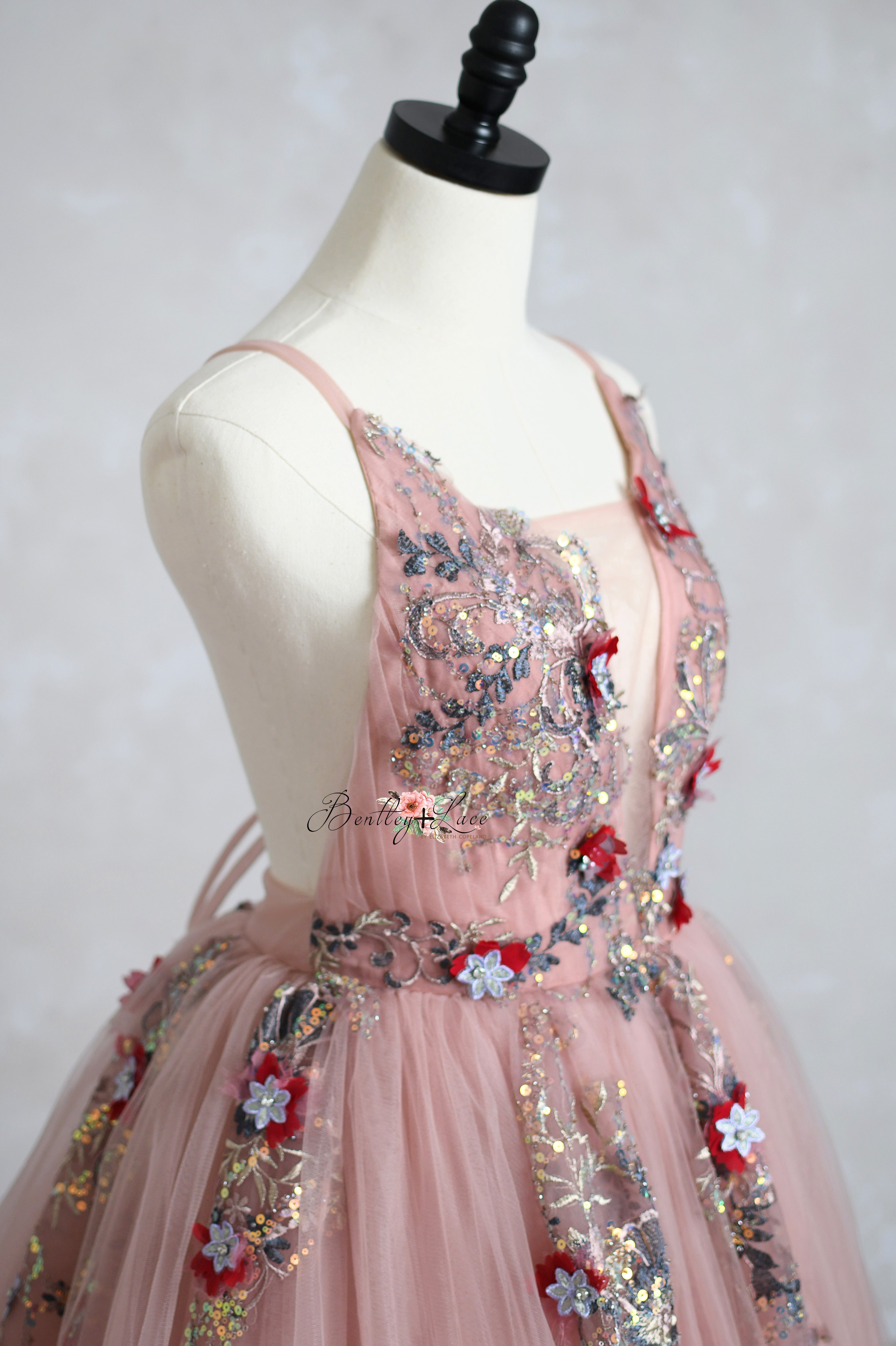 A mother and daughter wearing matching elegant gowns, ideal for photography sessions and special occasions.