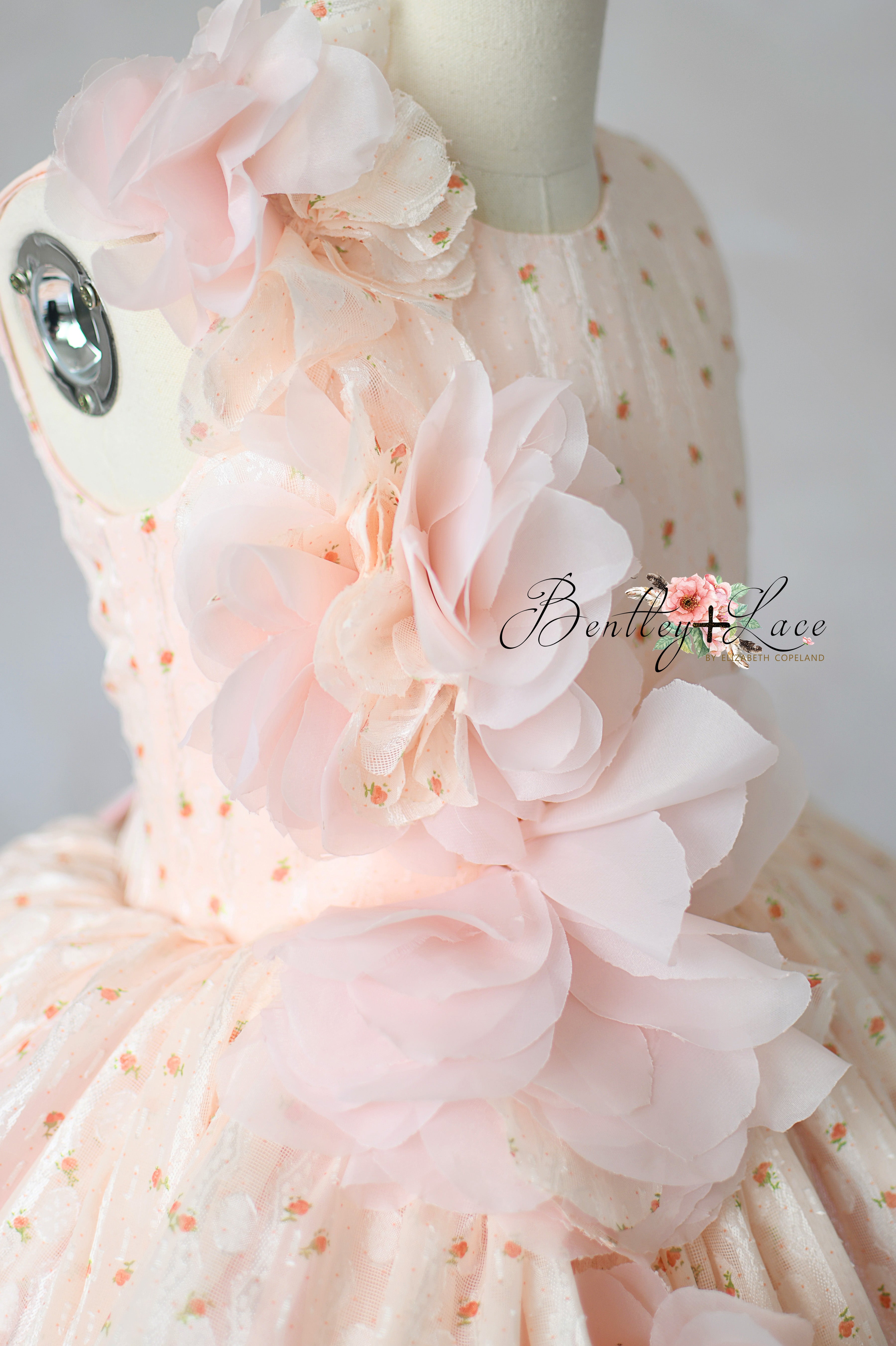 "Detailed close-up of soft floral embellishments on luxury girls gown"