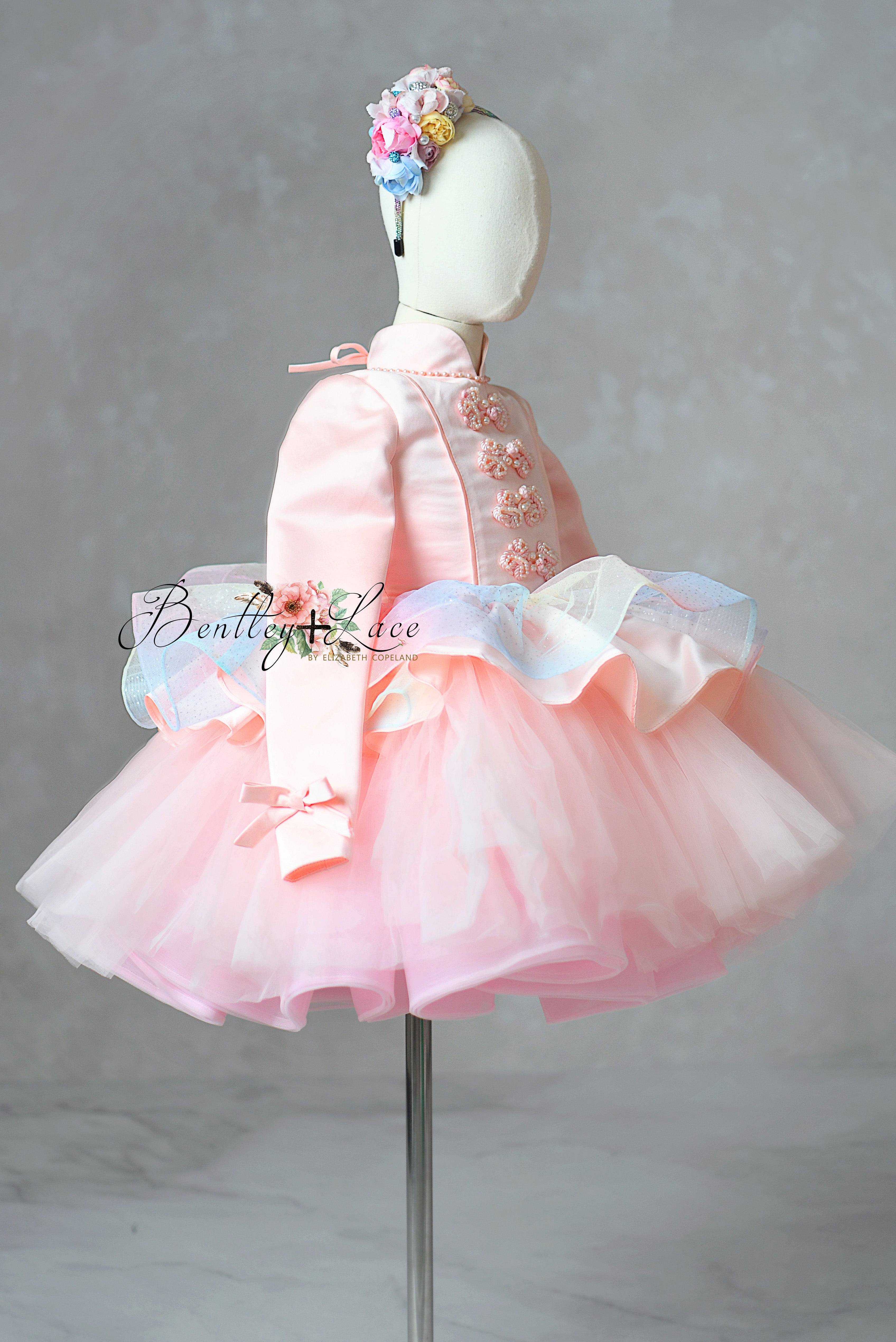 Pink dress with floral headband on a mannequin against a gray background