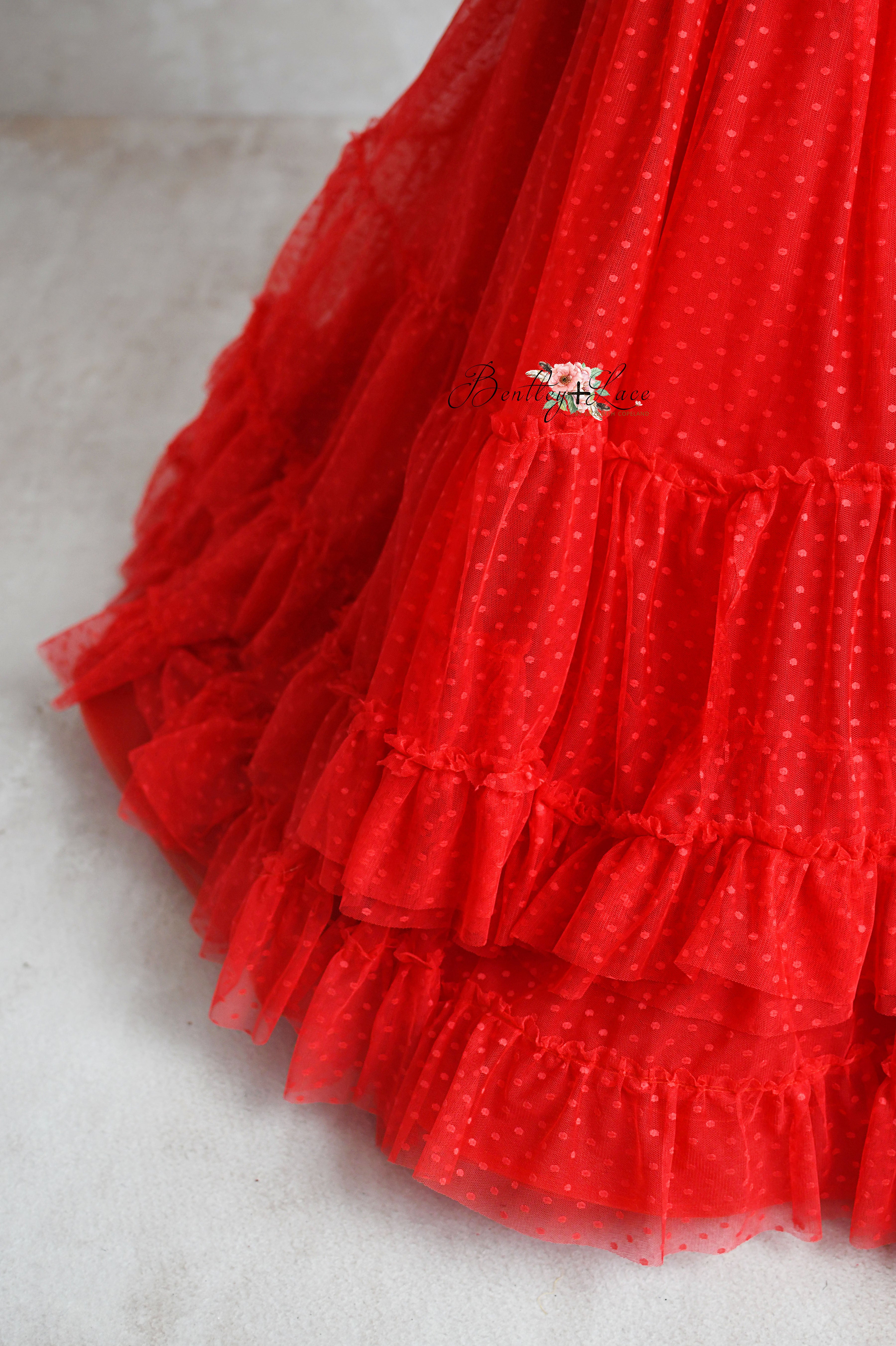 Custom red Swiss dot gown for girls with adjustable fit and layered skirt.