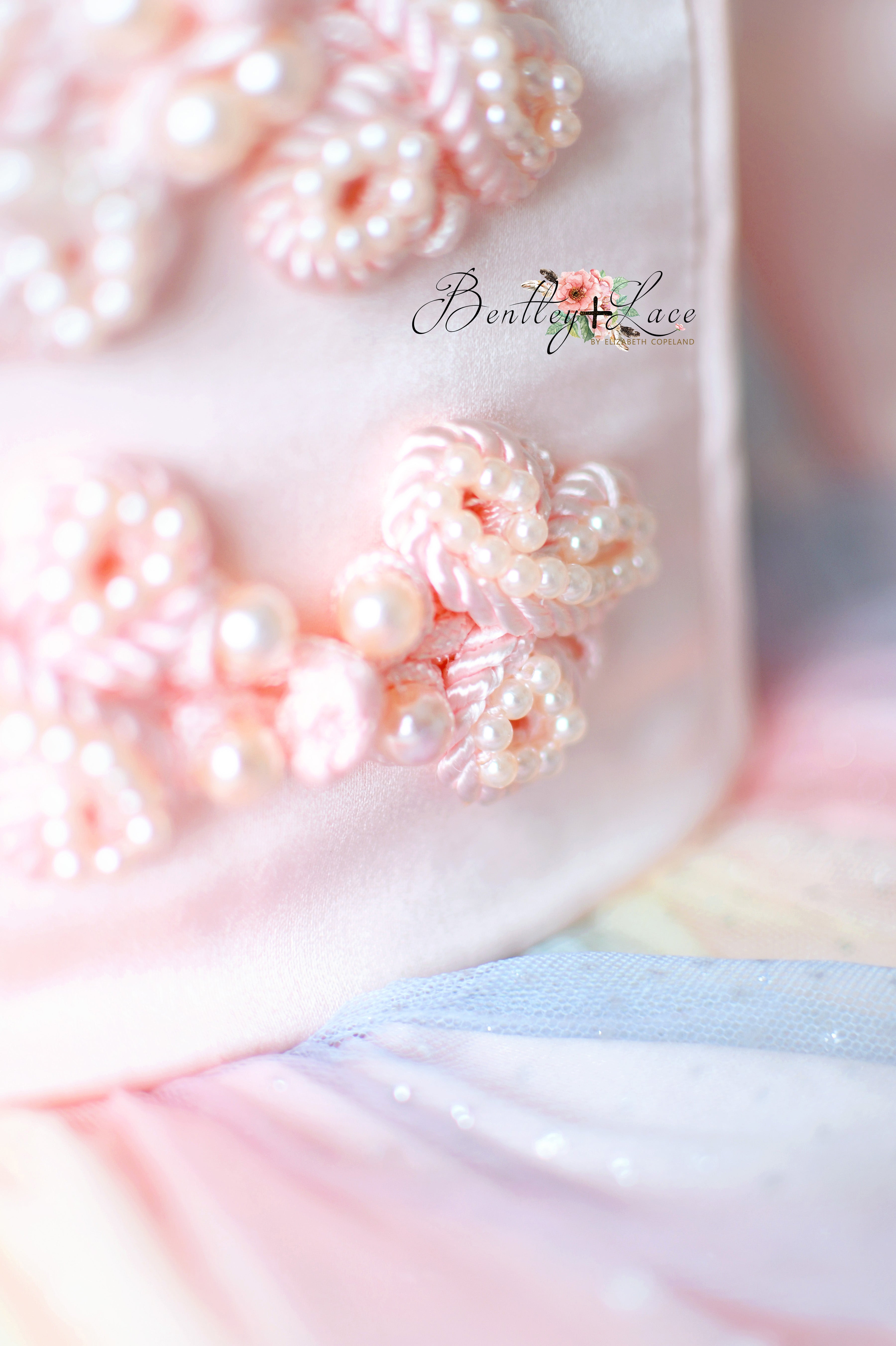 Close-up of decorative flowers with pearls on a textured surface, featuring the brand 'Bentilly Lace'.