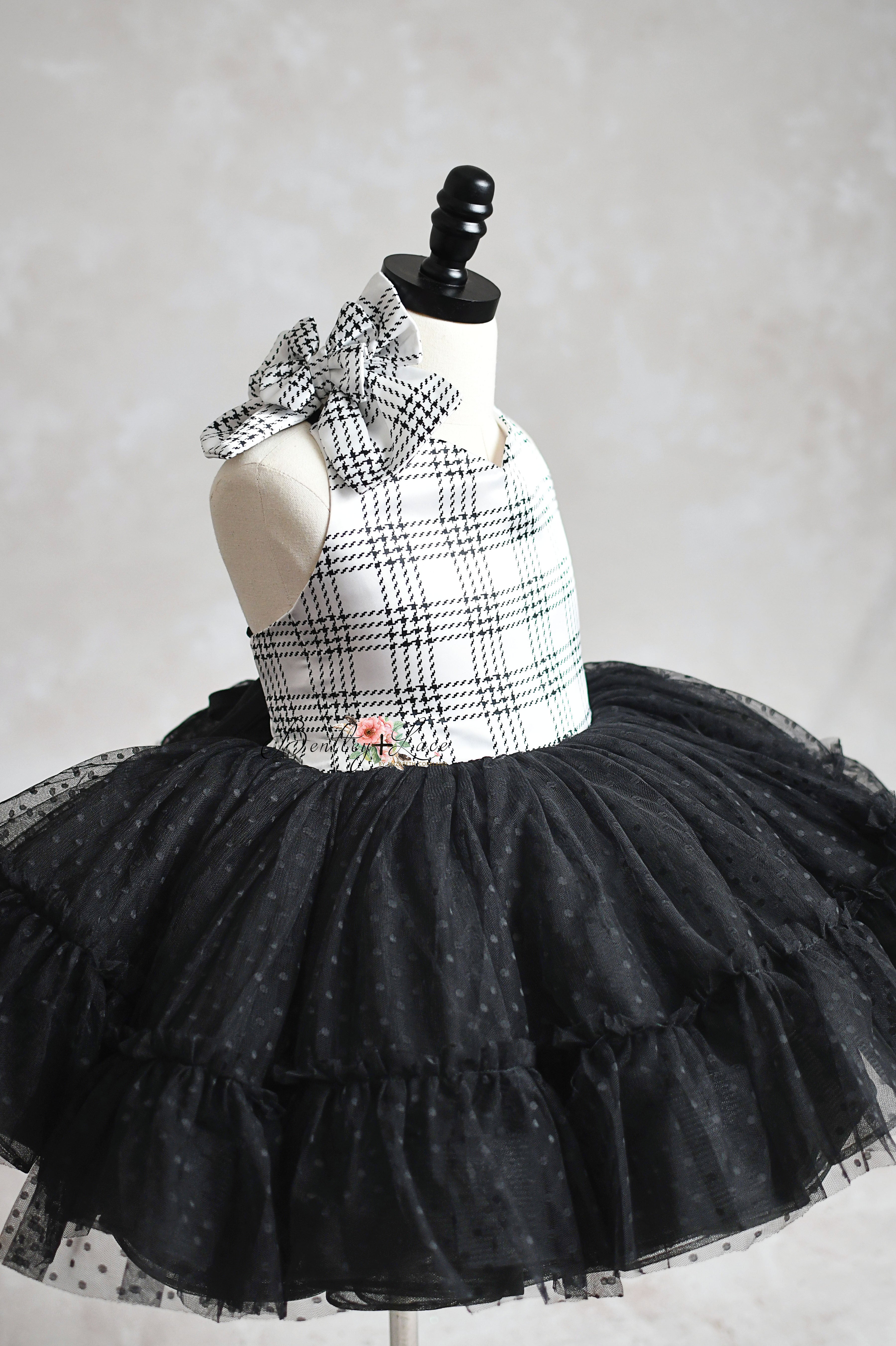 Stylish kids' dress with plaid bodice and adorable bow accent.