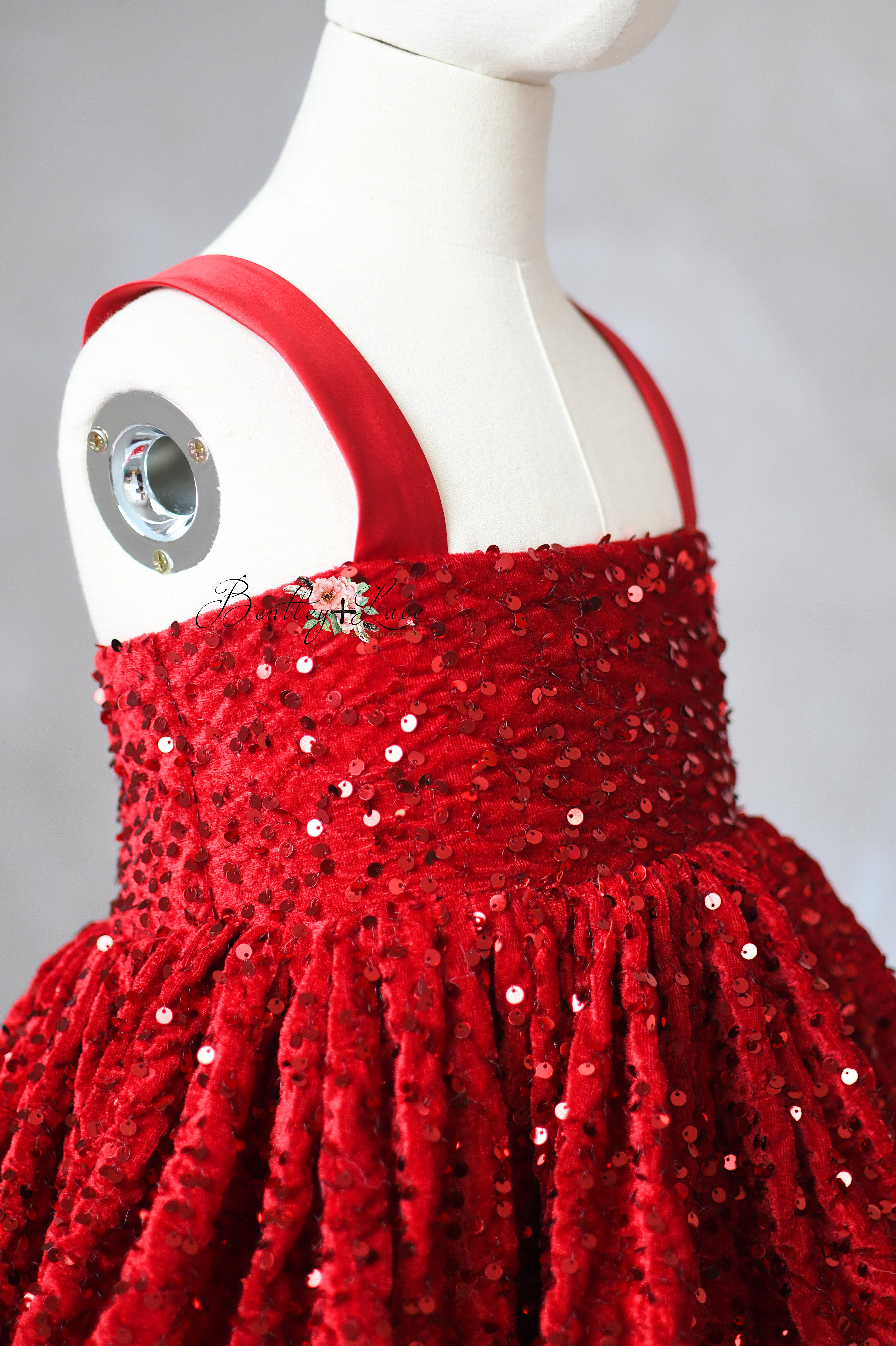 Red sequin dress on a mannequin against a gray background