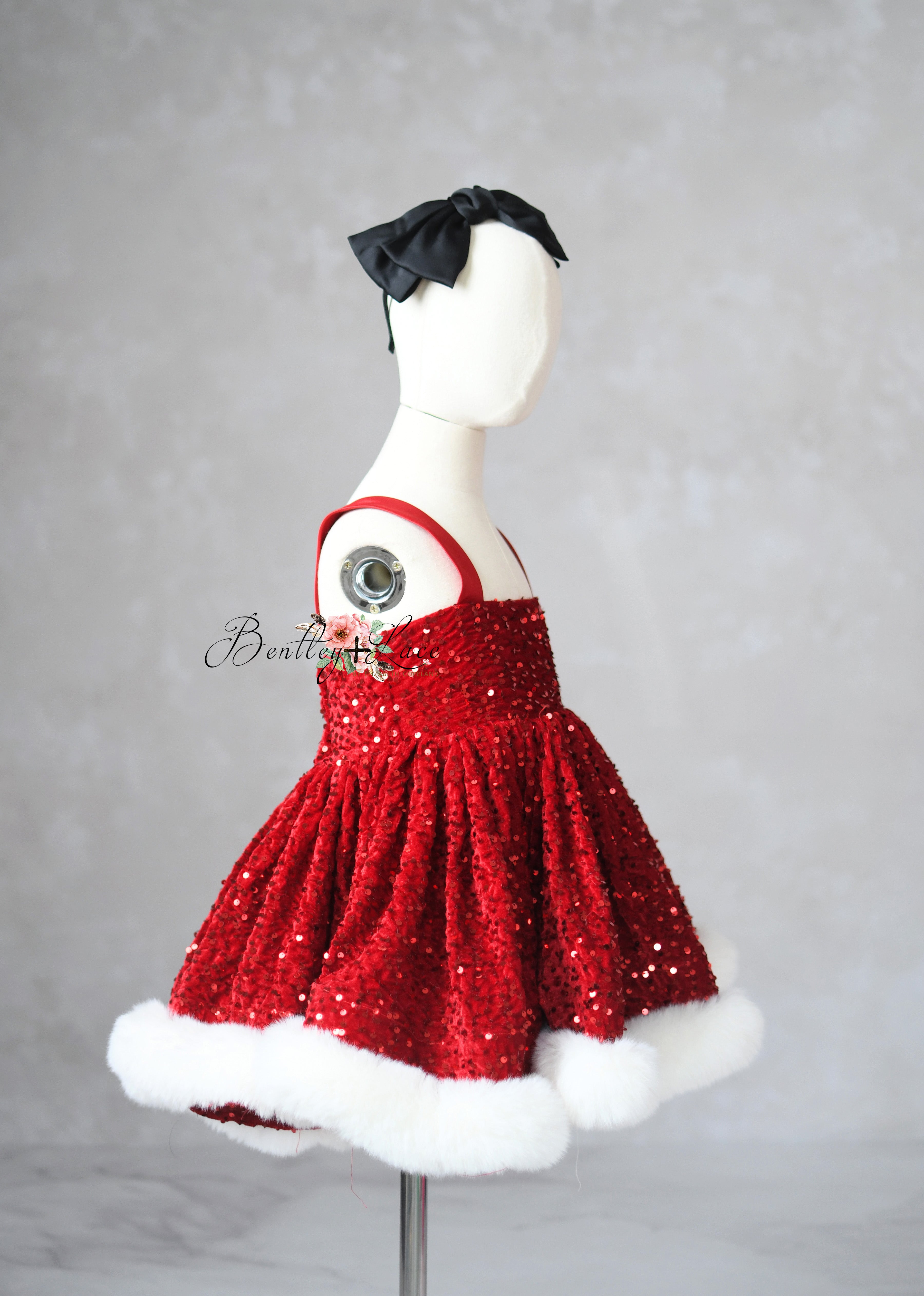 Red sequin dress with white trim on a mannequin against a gray background
