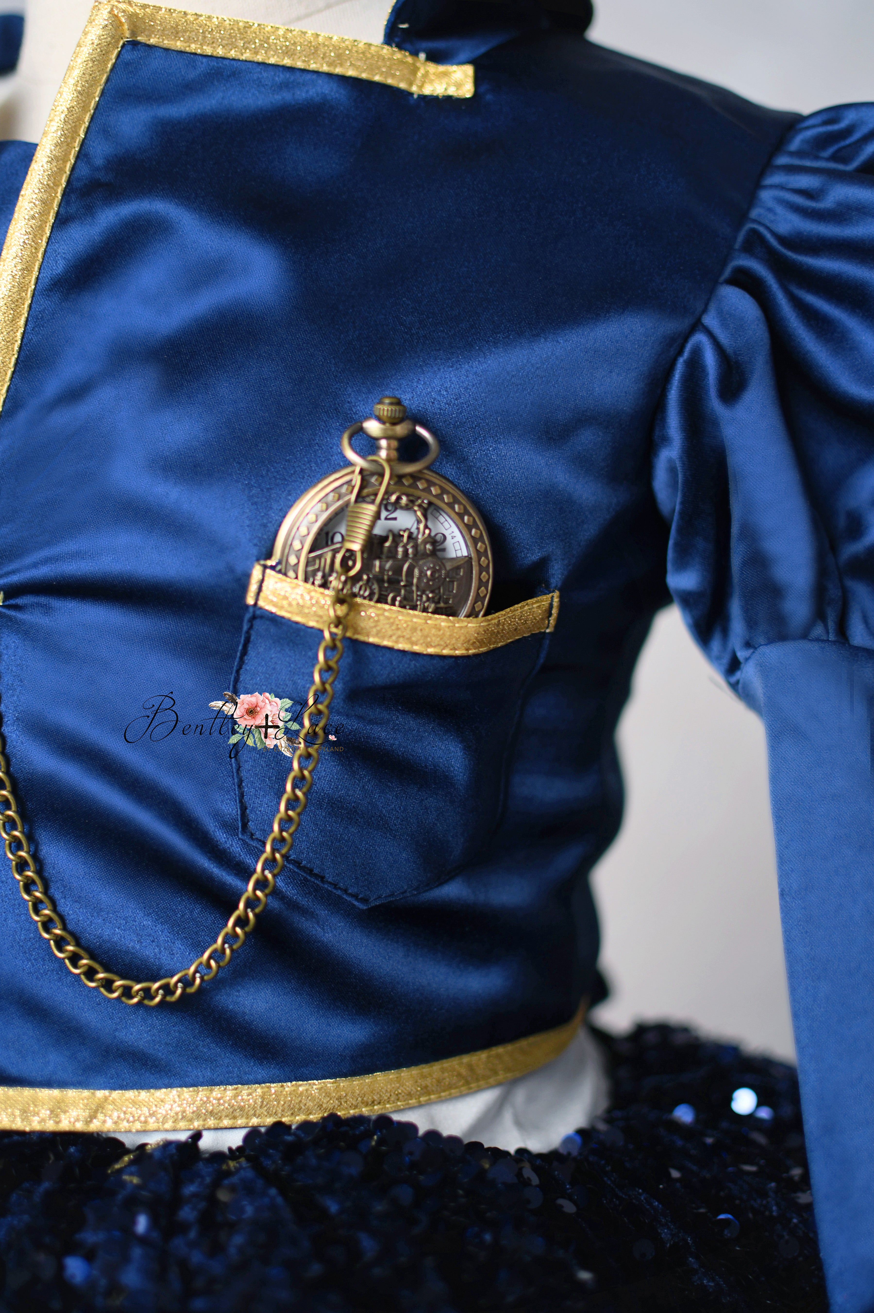 Mannequin wearing a navy sequin skirt with white trim and a blue sash on a plain background.