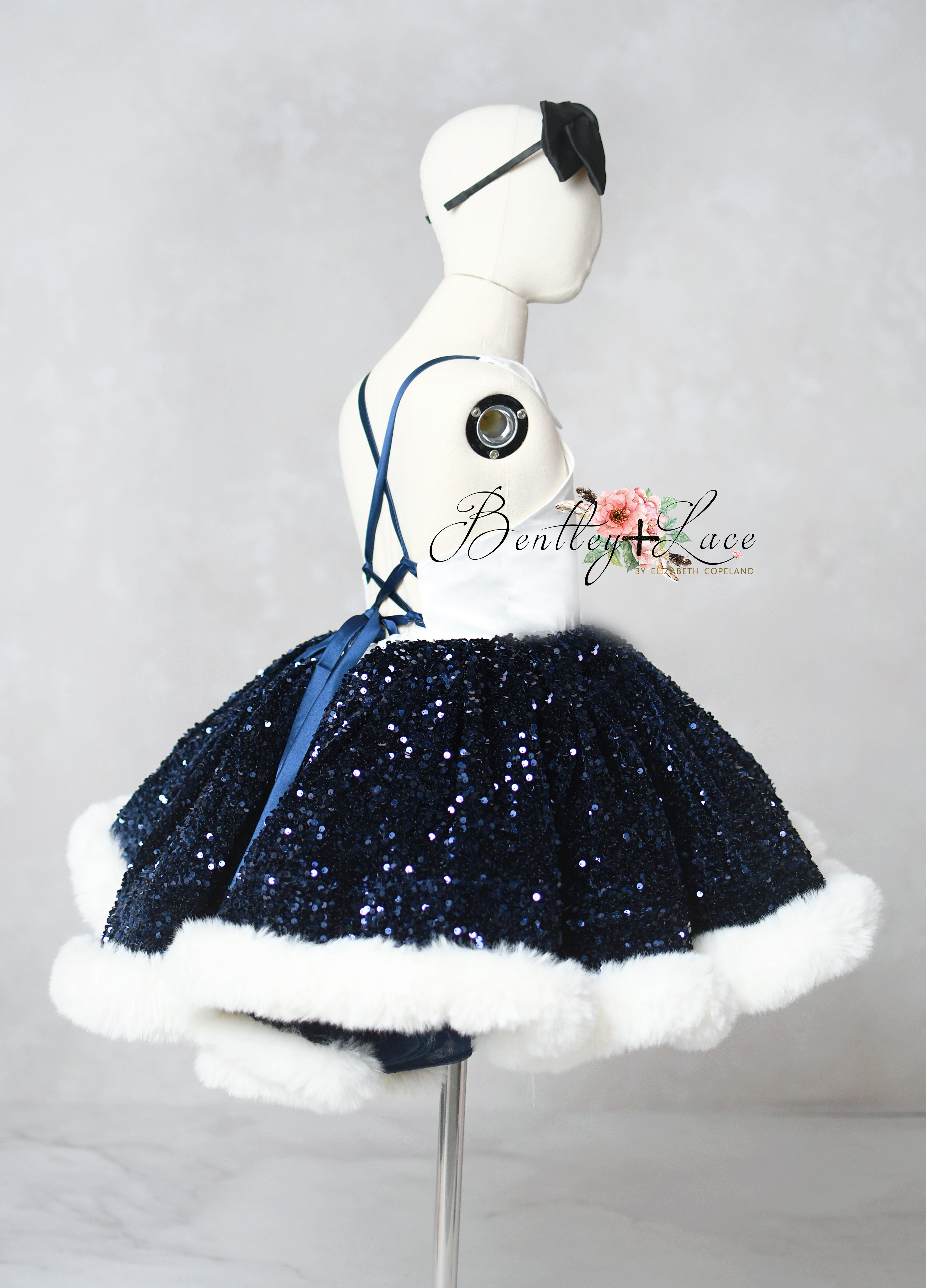 Mannequin wearing a navy blue sequin skirt with white trim on a gray background