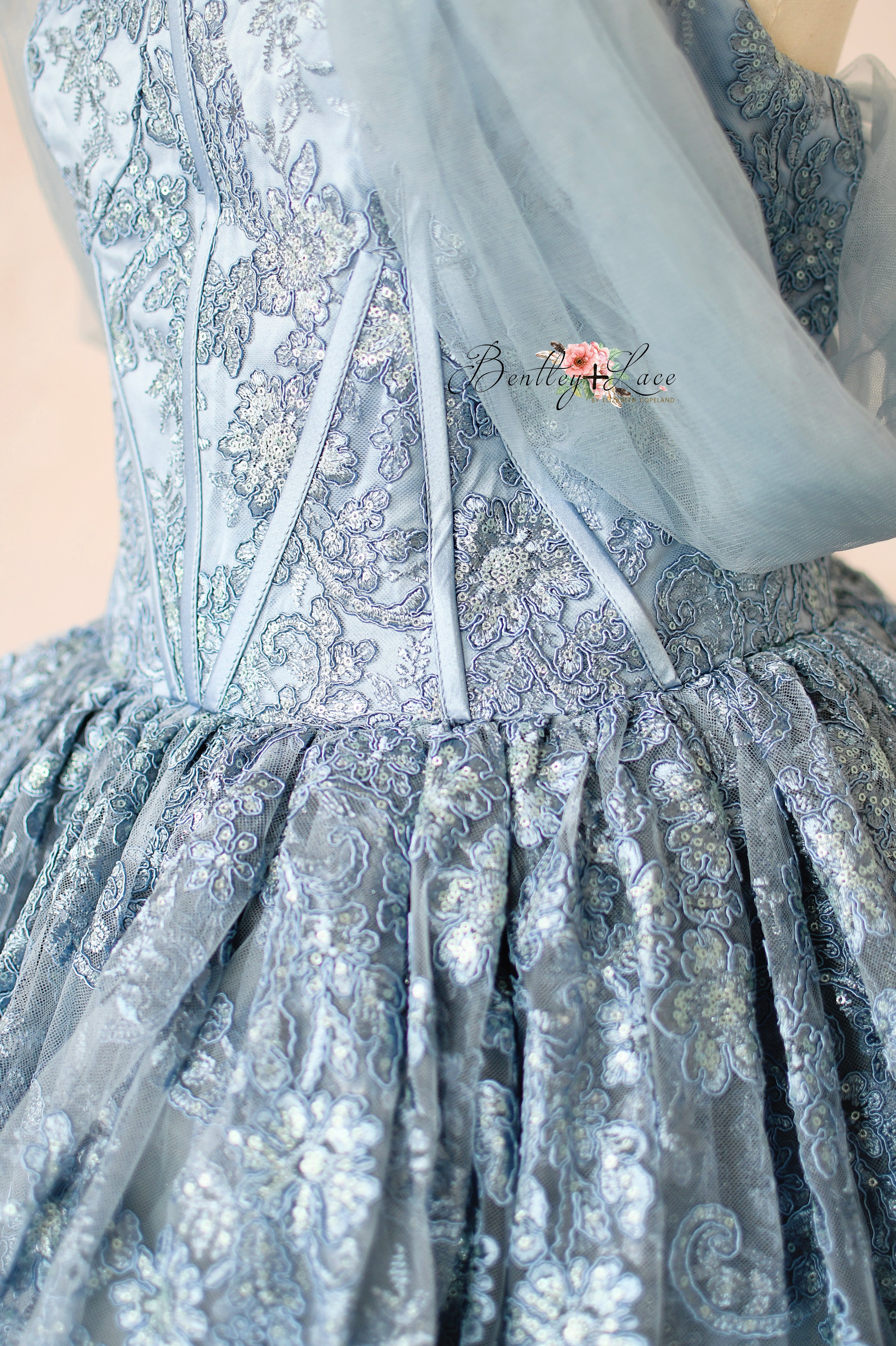 Close-up of a light blue embroidered dress with intricate patterns.