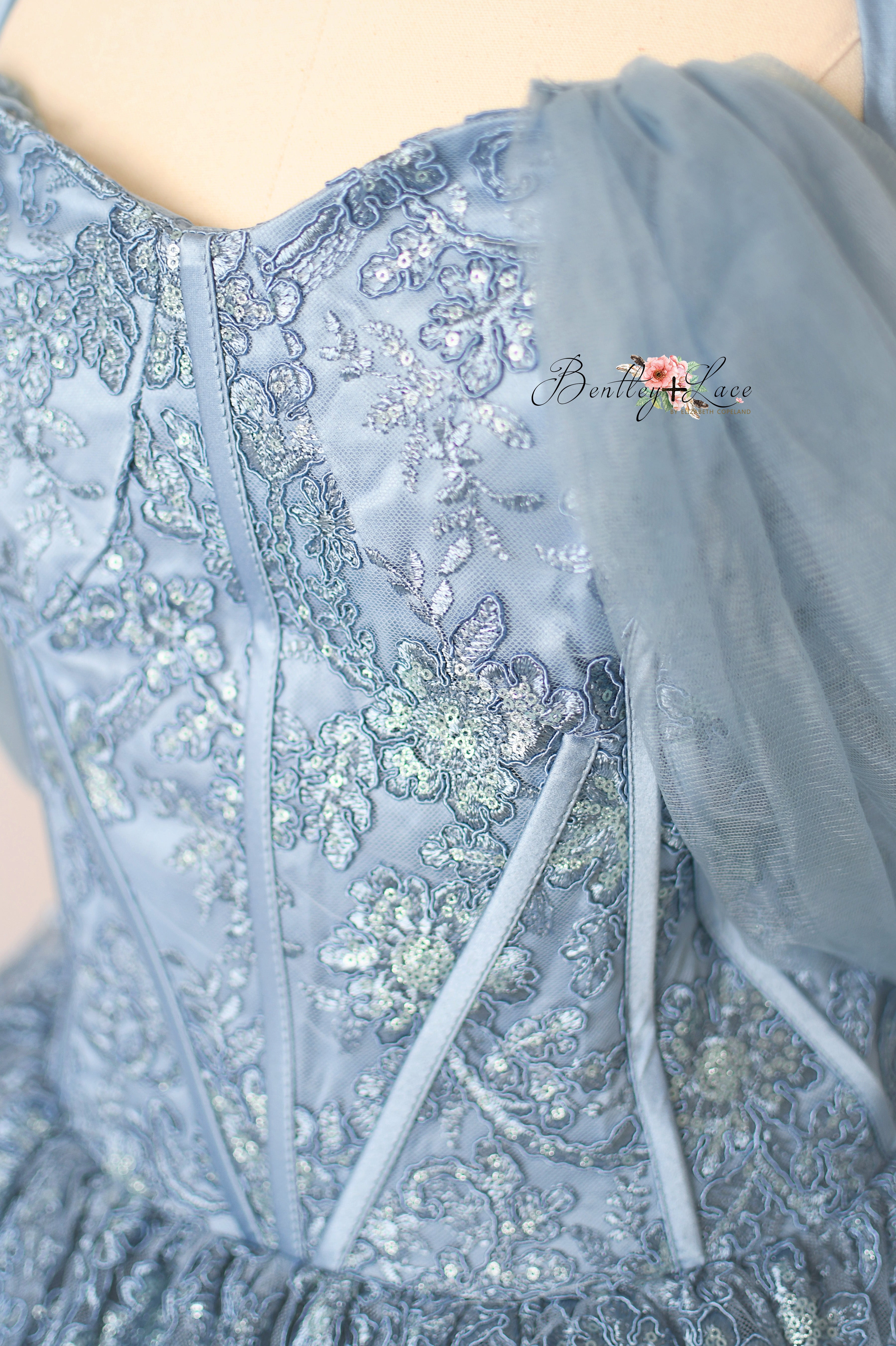 Close-up of a light blue embroidered dress with floral patterns.
