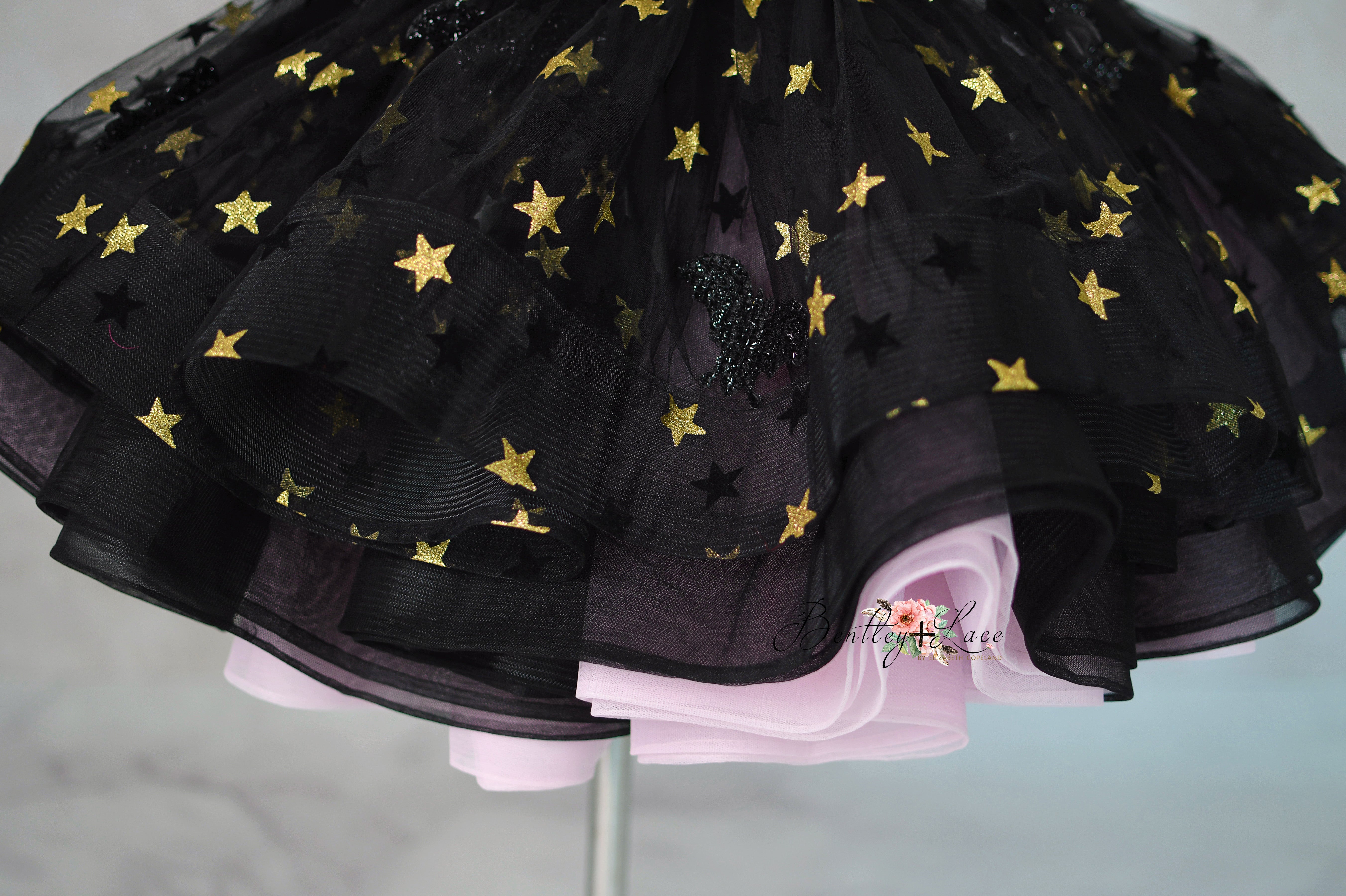 Black tulle skirt with gold stars on a gray background