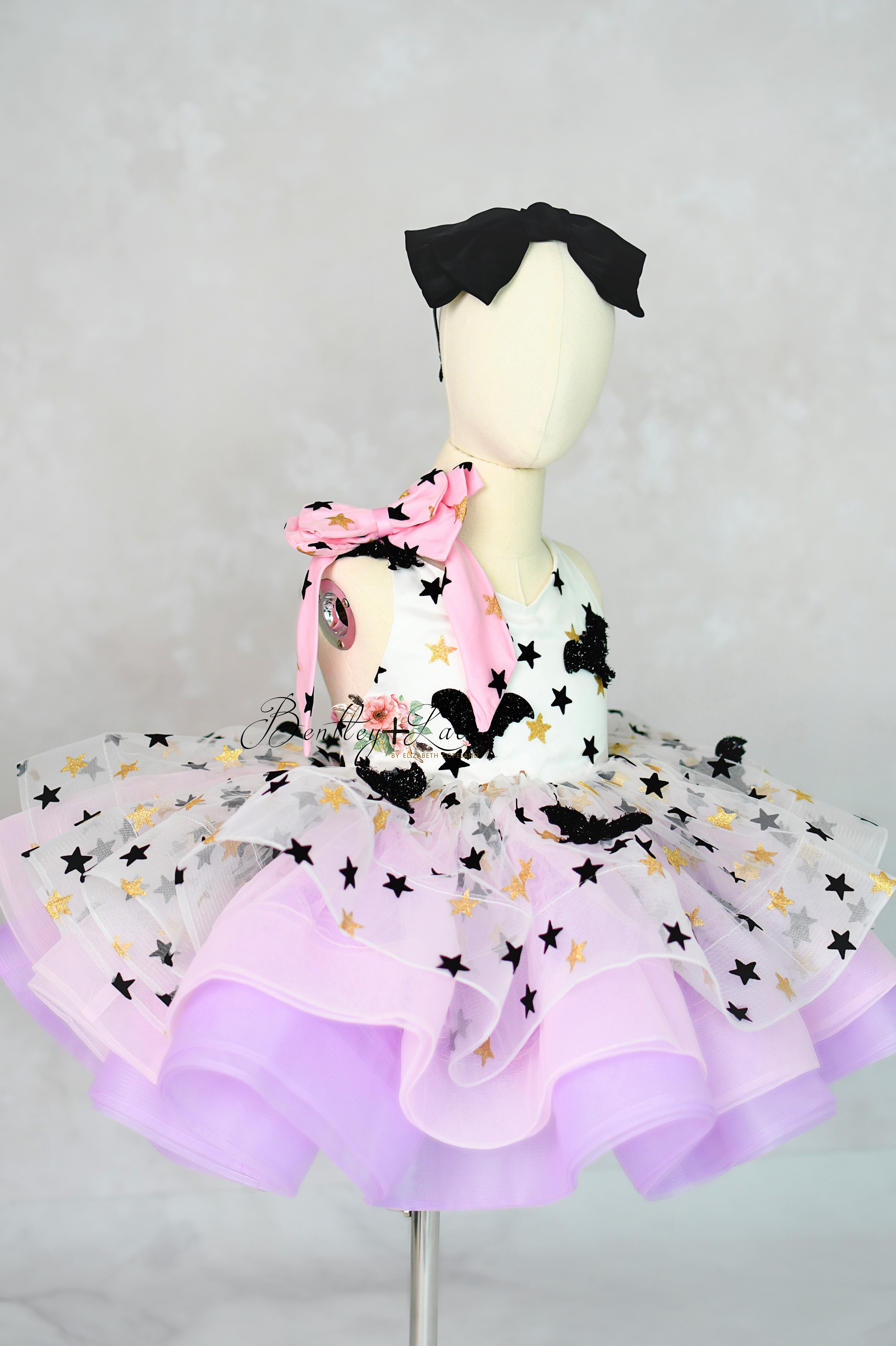 Mannequin wearing a colorful outfit with a purple skirt and black hair accessory on a gray background