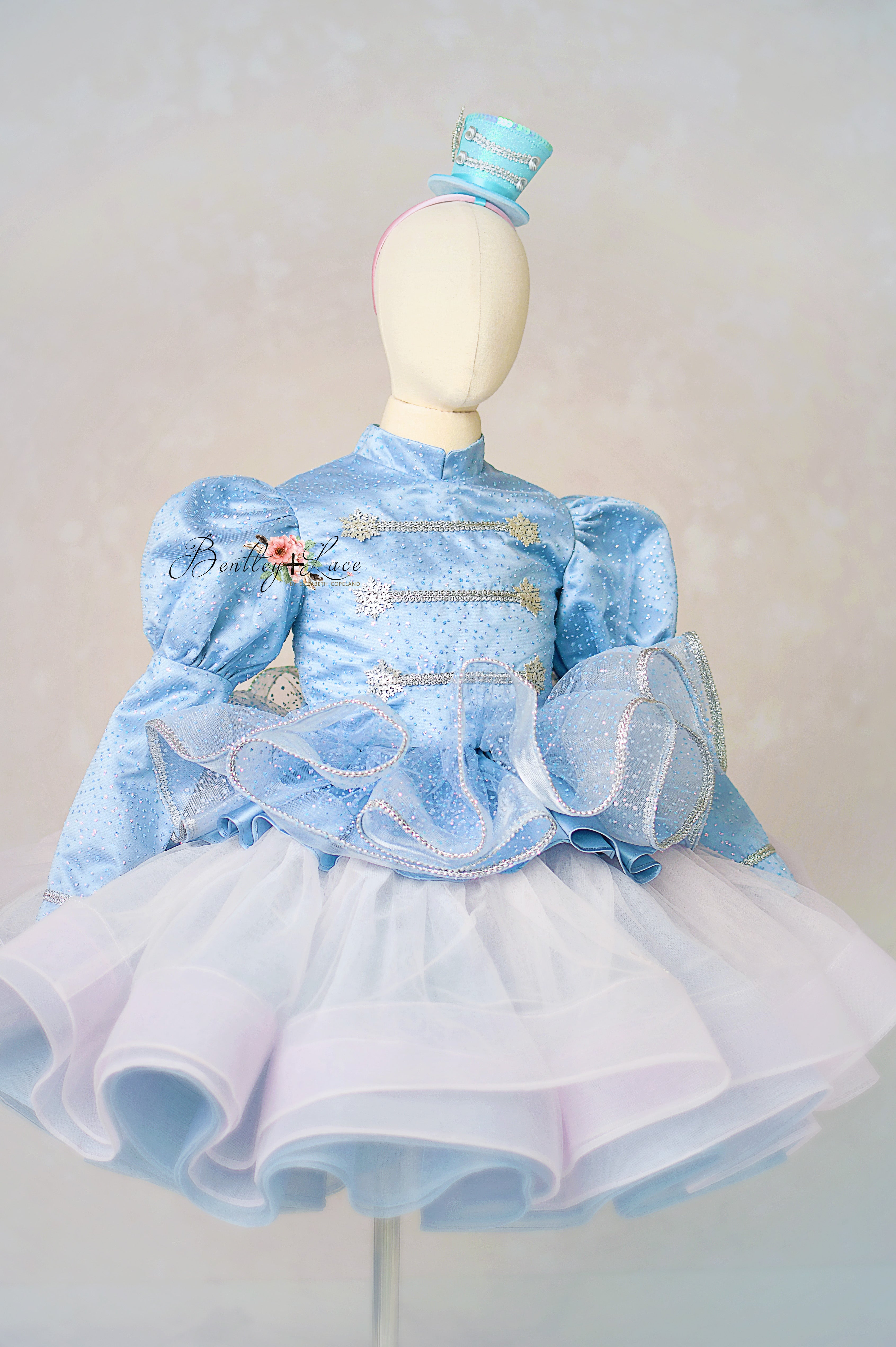 Light blue dress with ruffled details on a mannequin against a plain background