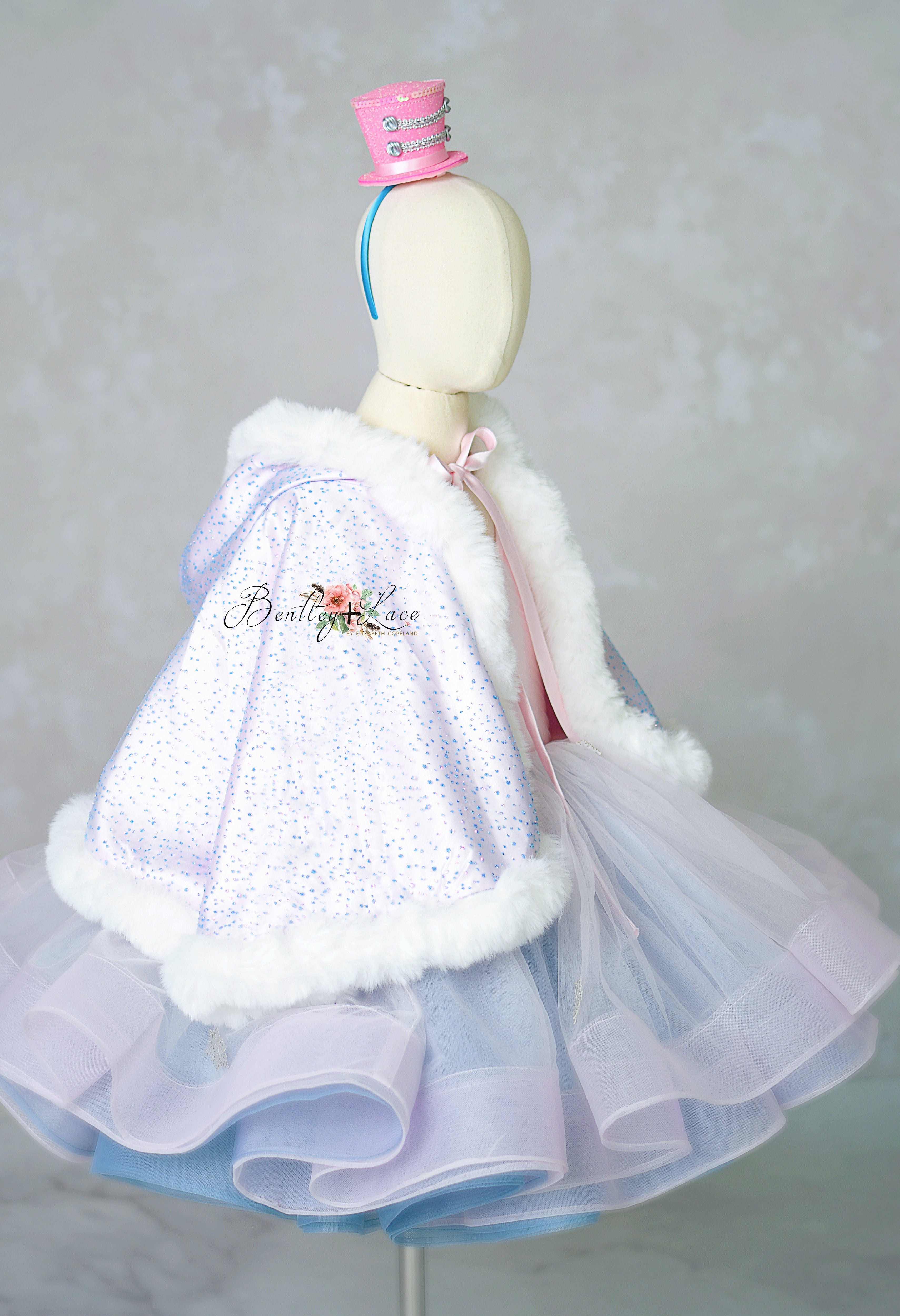 Mannequin wearing a light purple dress with white fur trim against a plain background