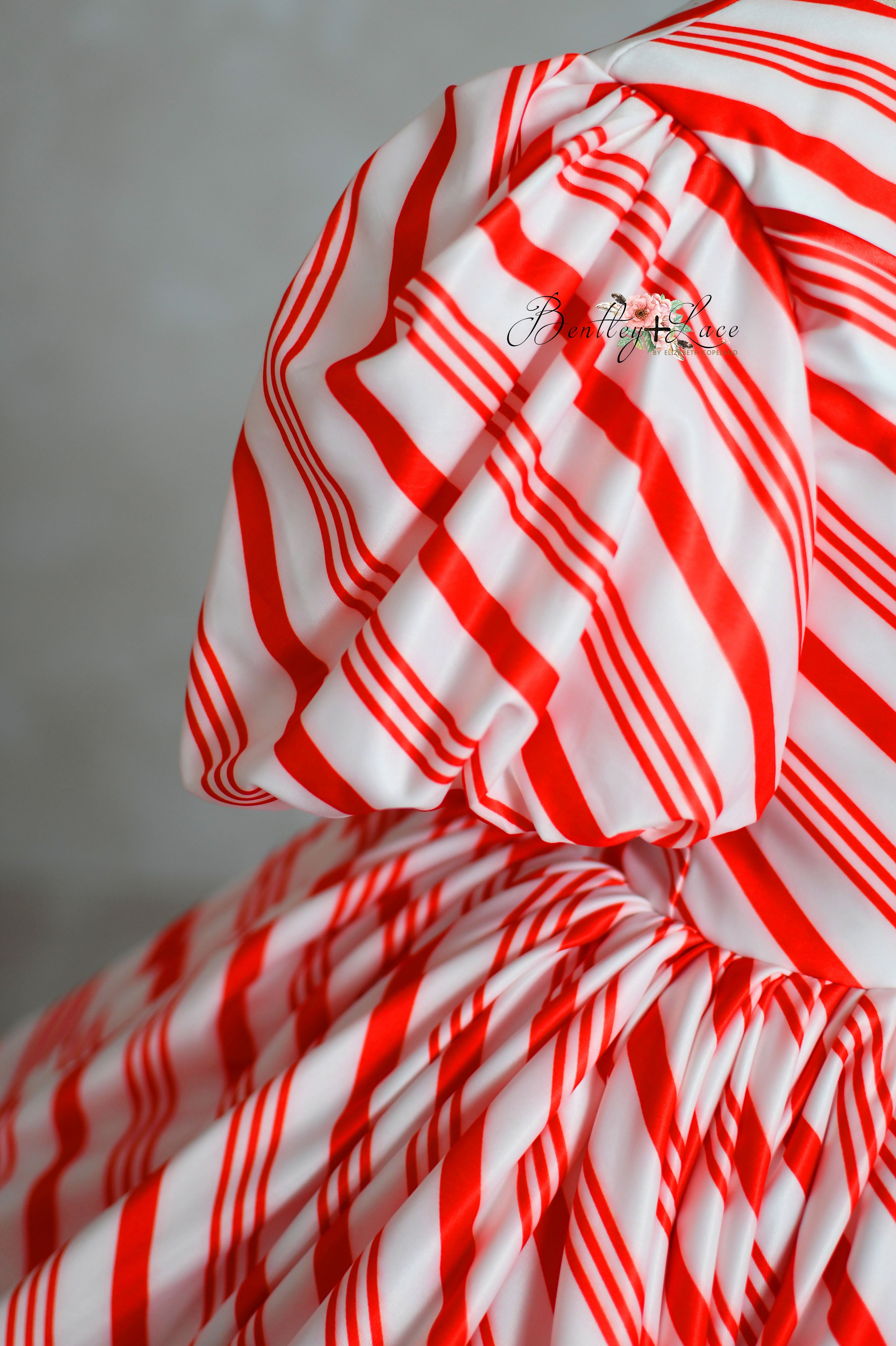 red and white striped Candy Cane Lane Dress for a Christmas photo session.