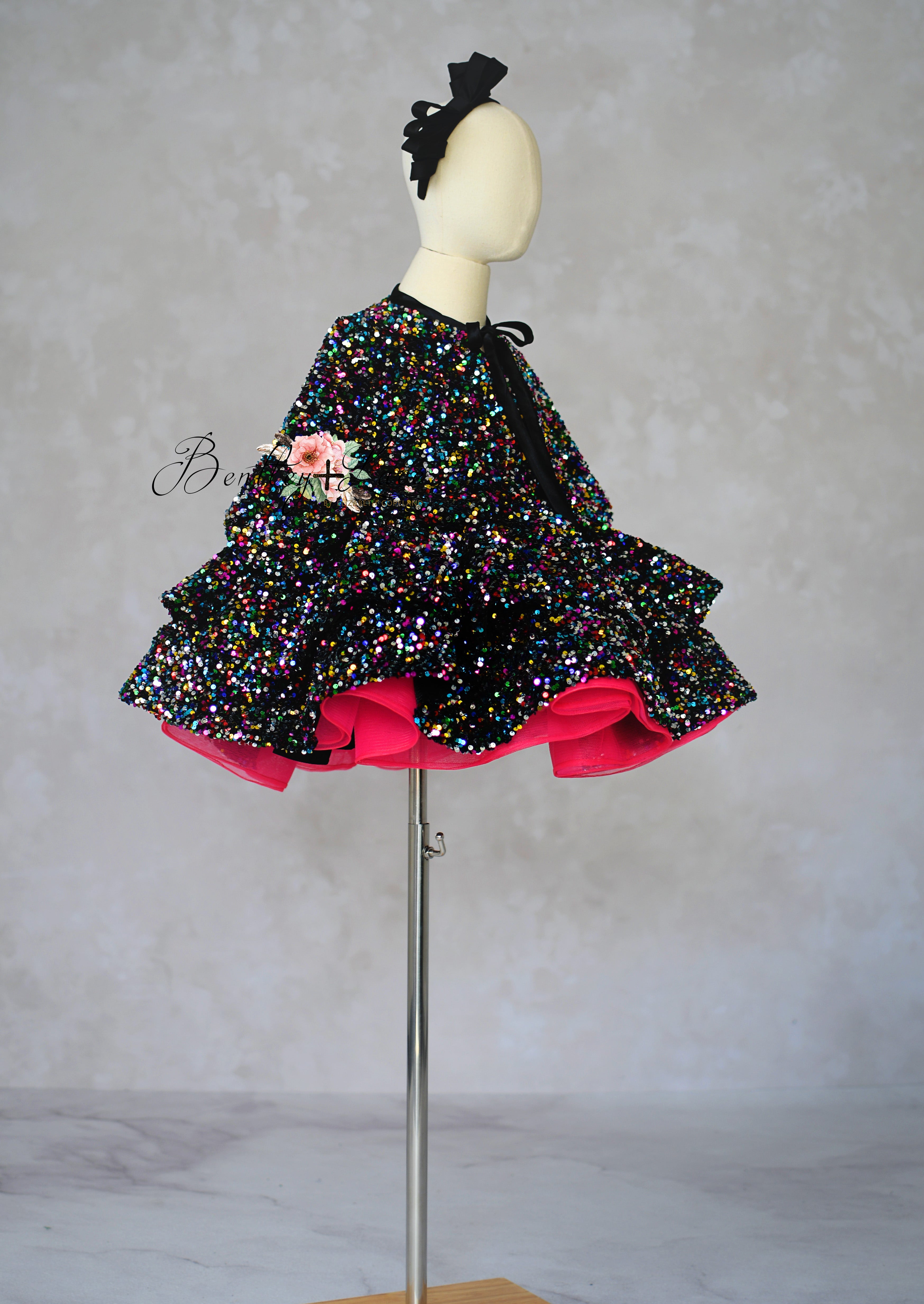Mannequin wearing a colorful dress with a black top and pink bottom on a gray background