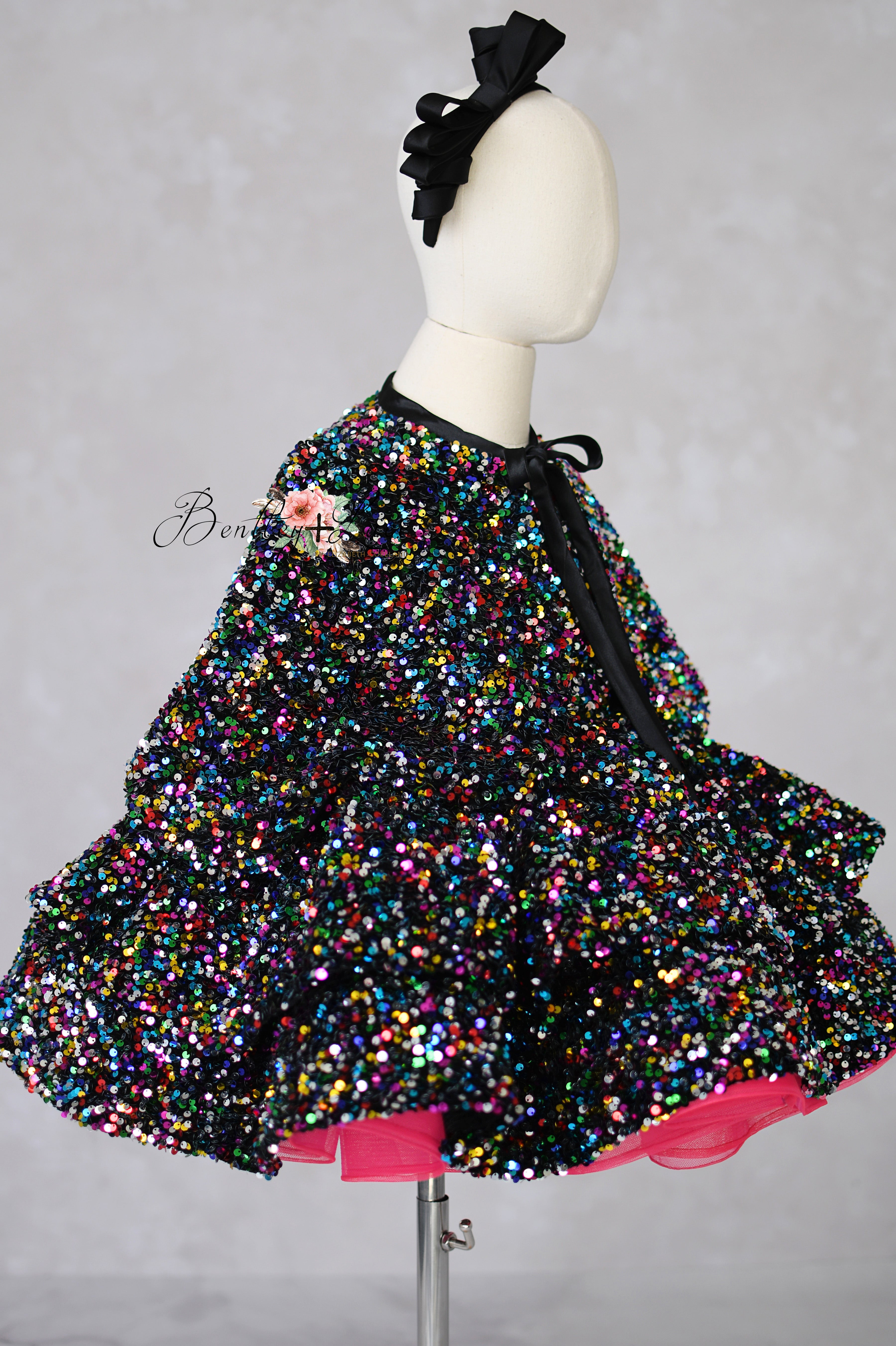 Multicolored sequin skirt with pink base on a mannequin against a gray background
