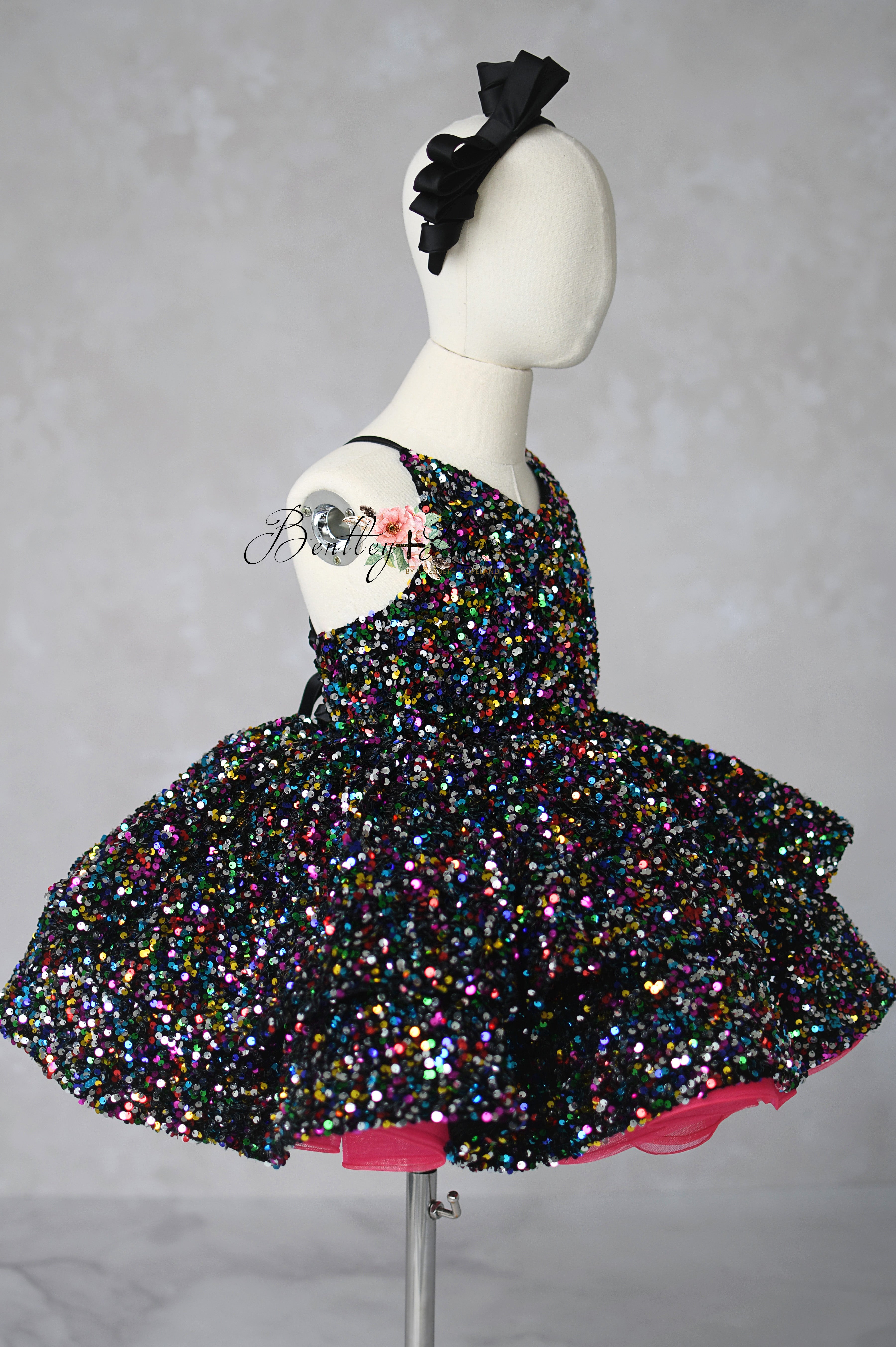 Multicolored sequin dress on a mannequin against a gray background