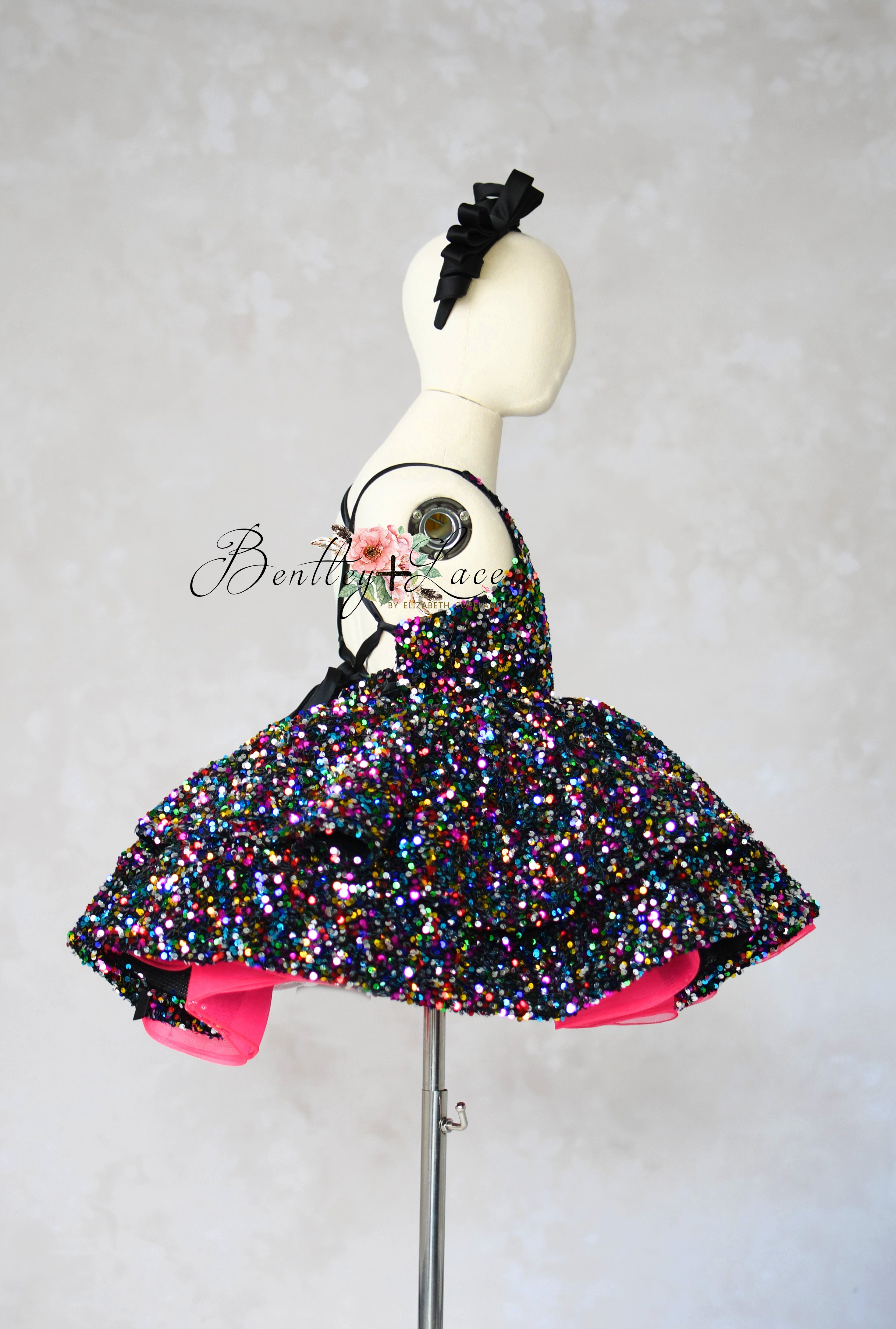 Multicolored sequin dress on a mannequin against a plain background