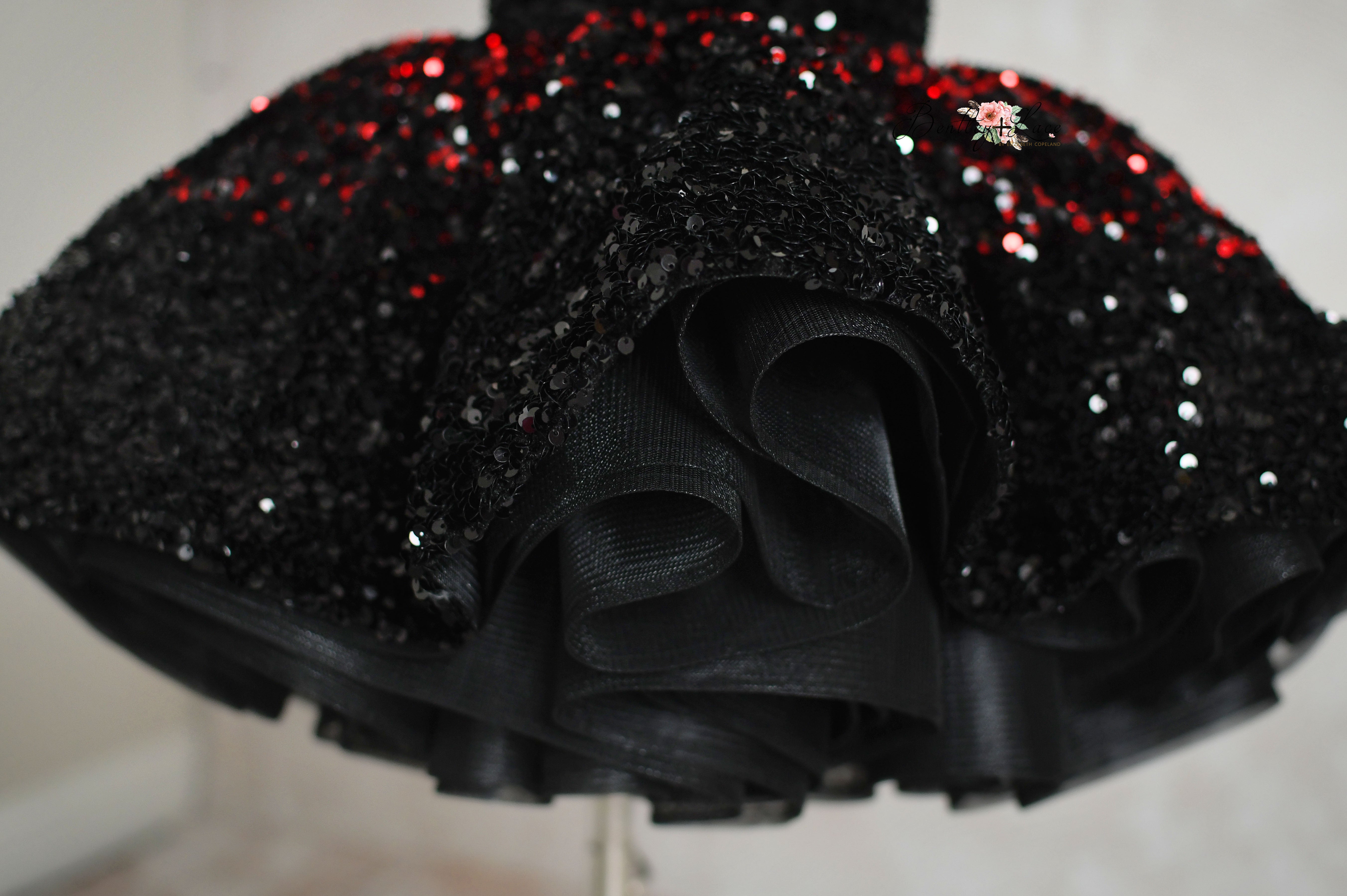Red and black sequin velvet short dress with elastic waist and adjustable shoulder ties for a custom fit.