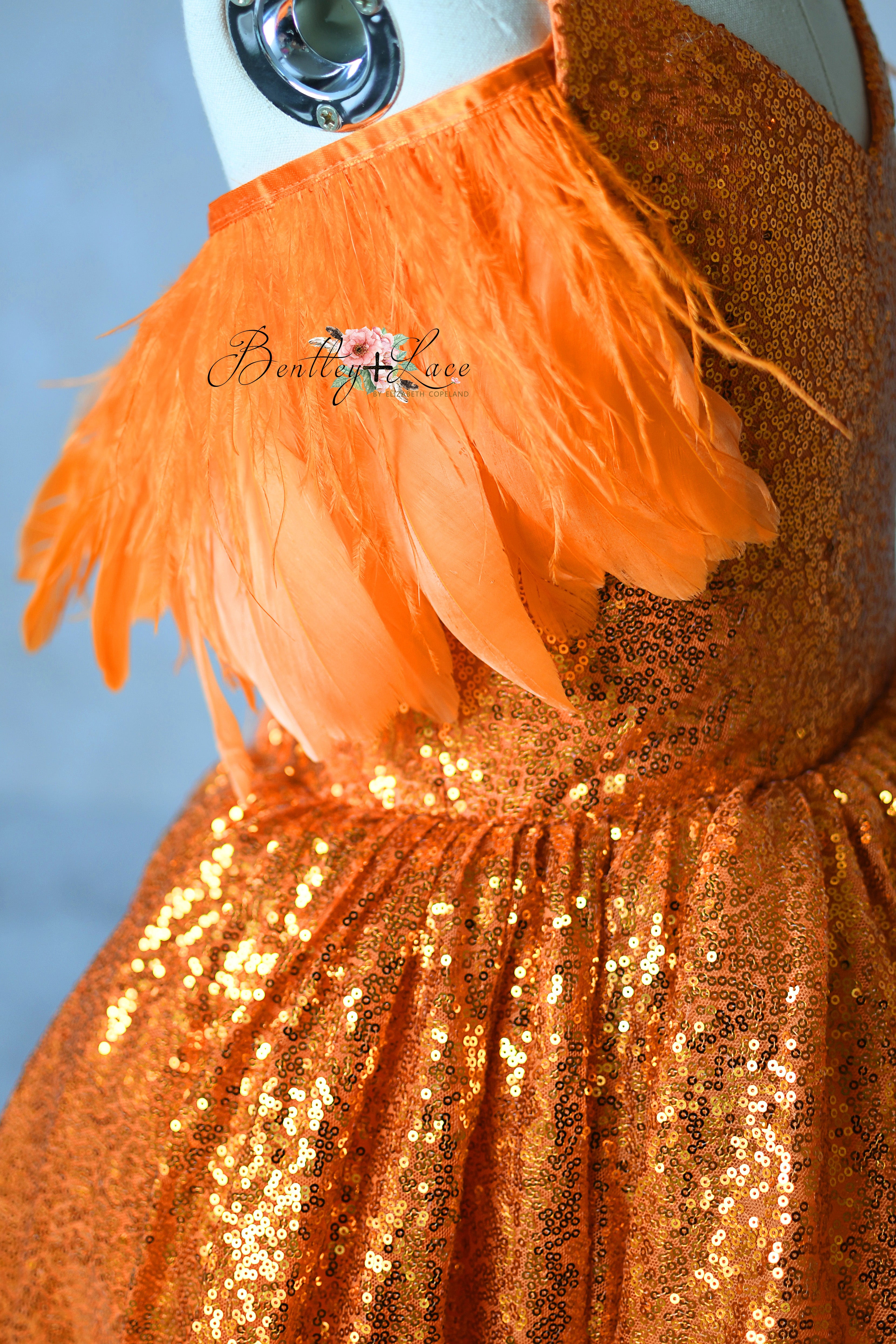 High-low orange glitter gown with optional feather off-shoulder straps and hidden mint detail