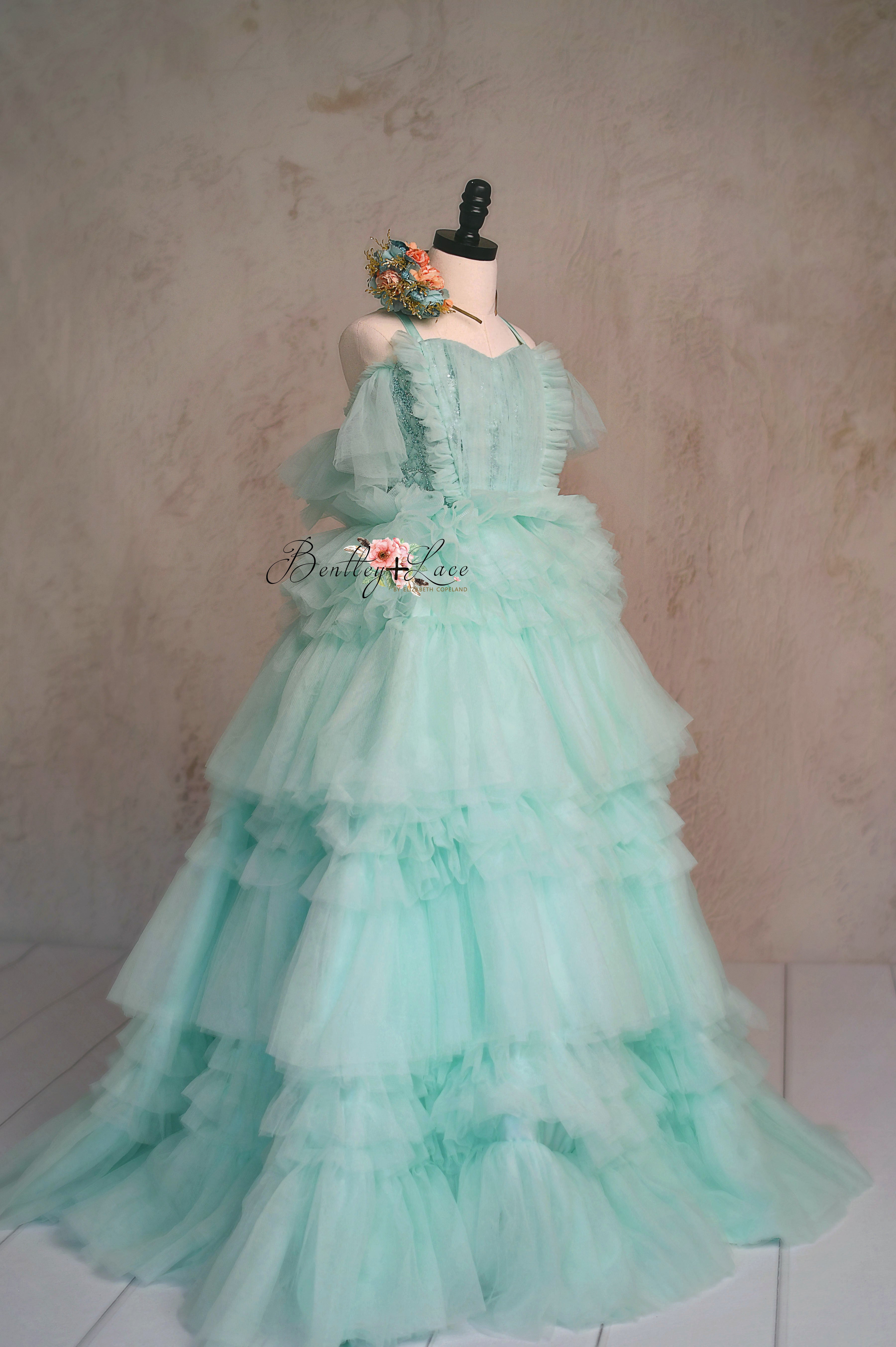Girls' aqua gown featuring delicate tulle and ruffles.