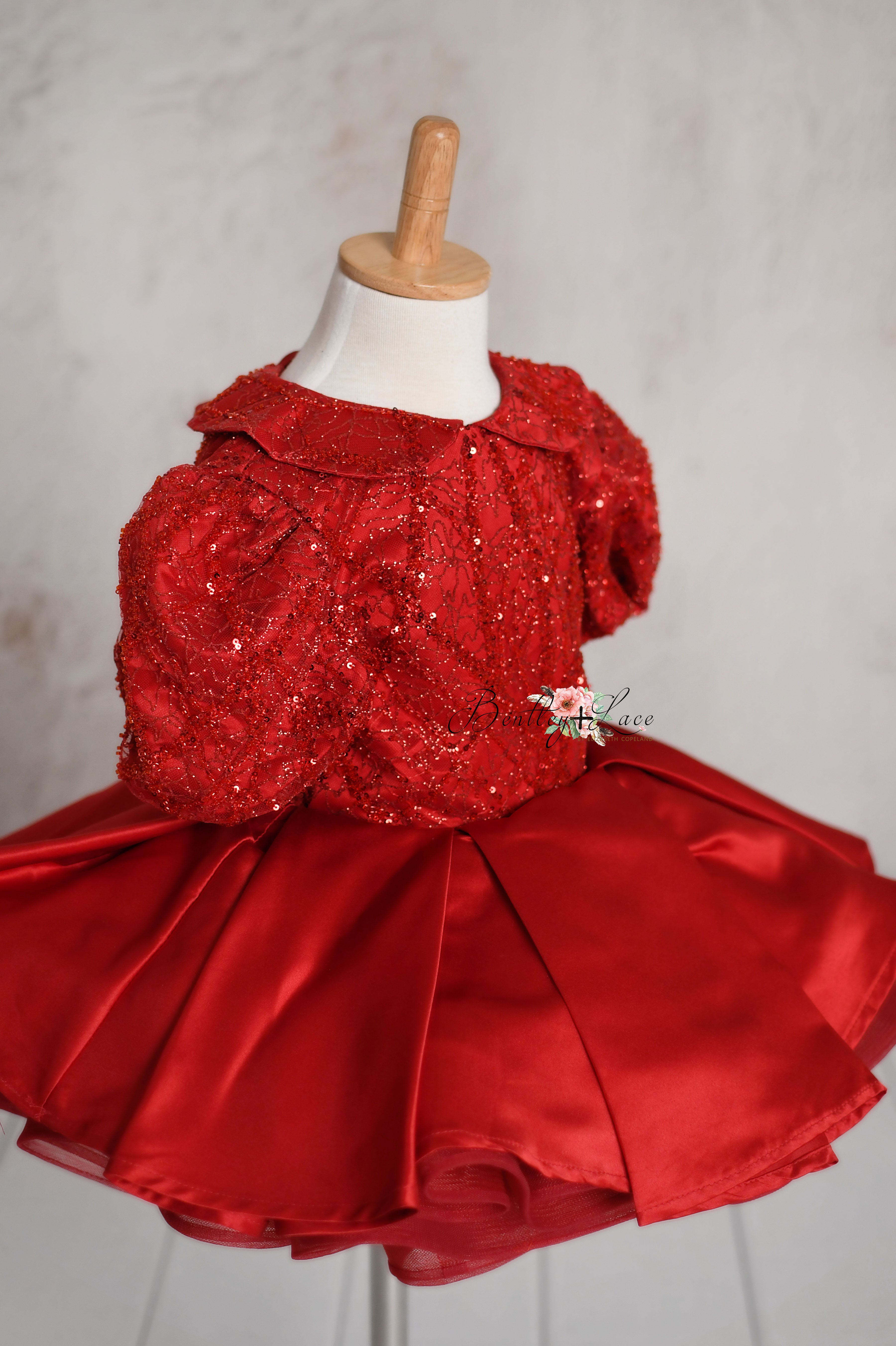 Front view of a red sequin gown for girls with a Peter Pan collar and puffed sleeves, designed for ages 3-4 years.