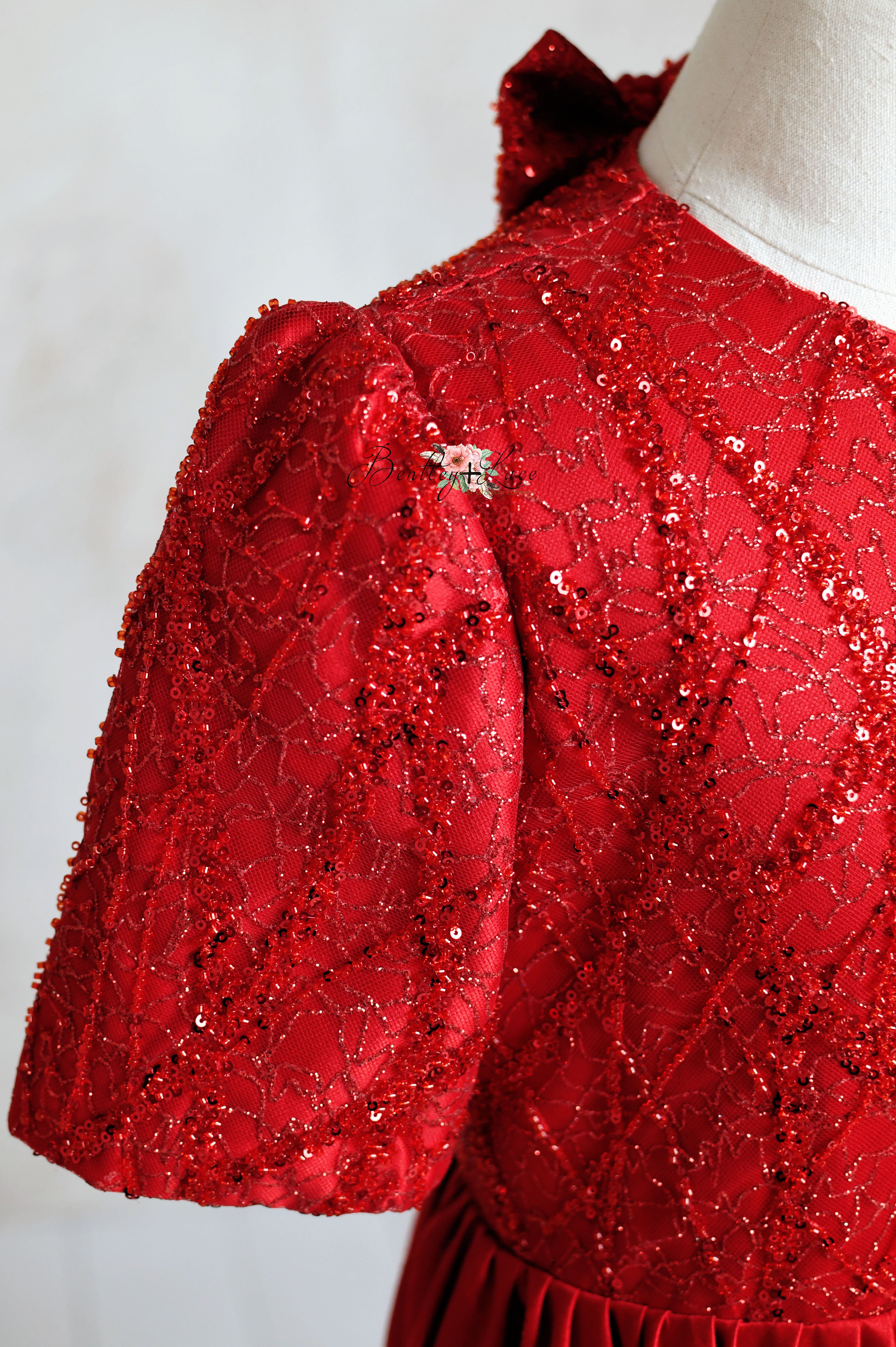 Red silk satin dress with a fitted bodice and flowing skirt, perfect for special occasions.