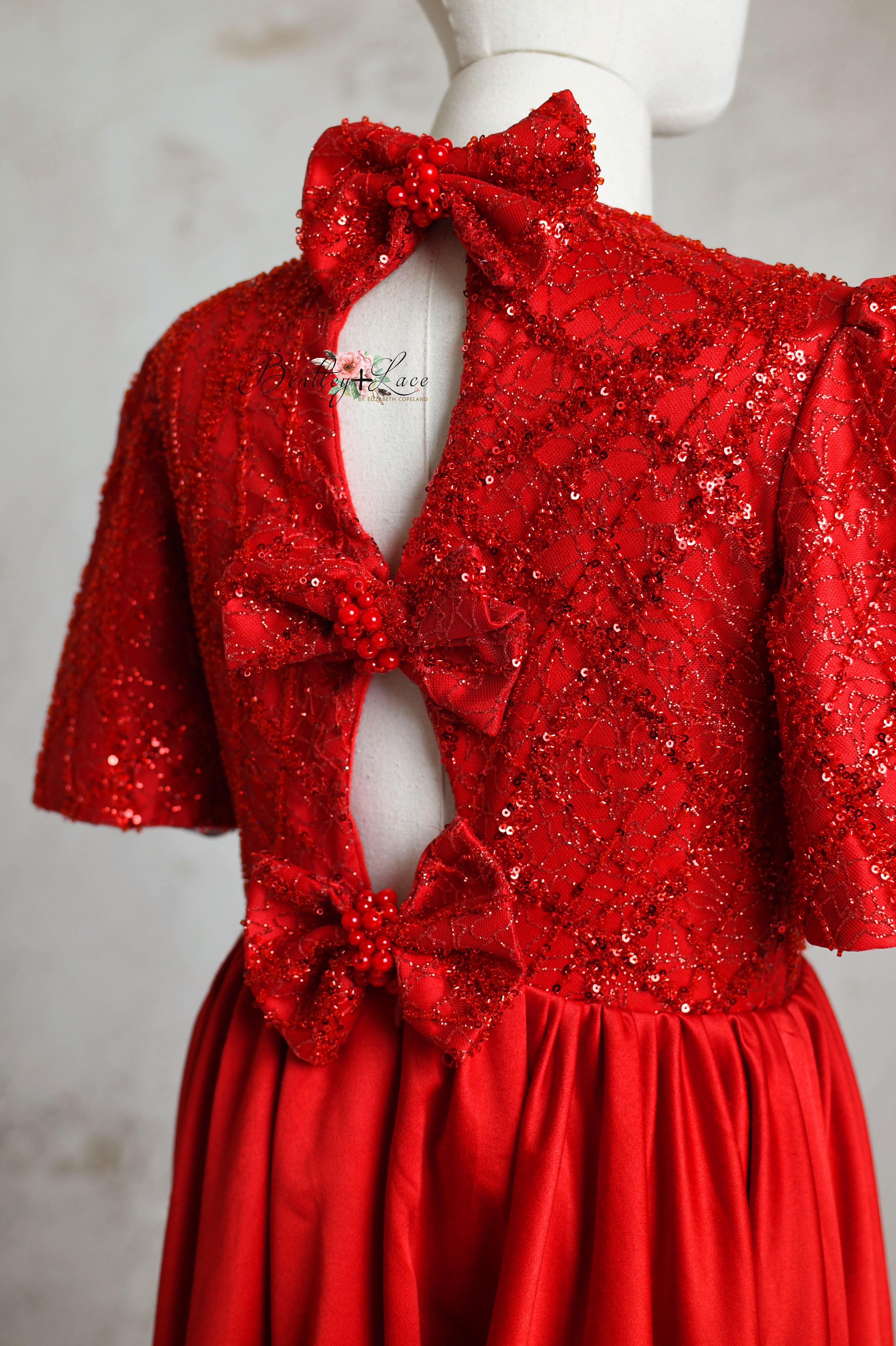 Close-up of a luxurious red silk satin dress with delicate details.