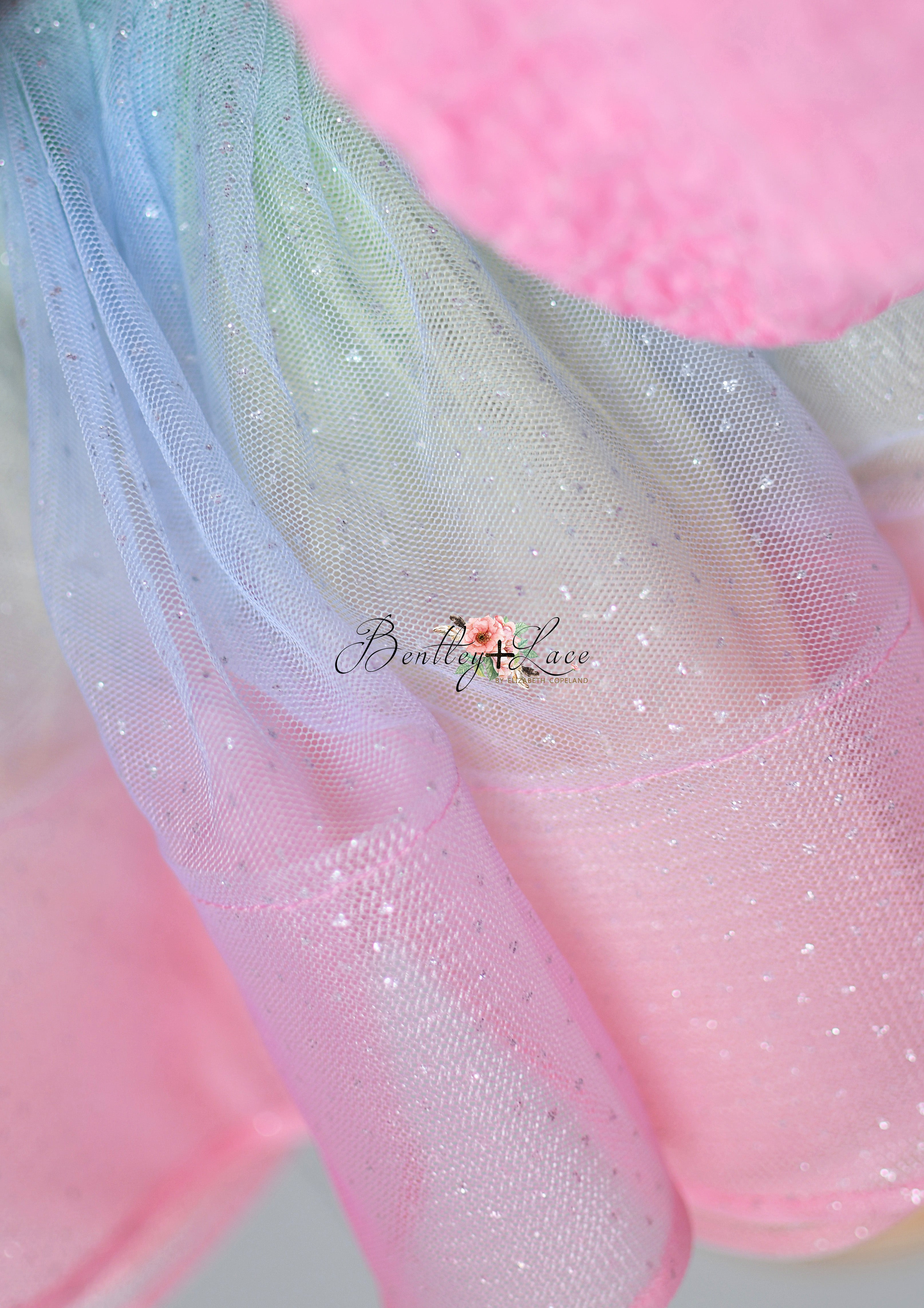A vibrant and glittering pink sequin dress with a flared skirt, showcased on a wooden stand with a minimalist backdrop.
