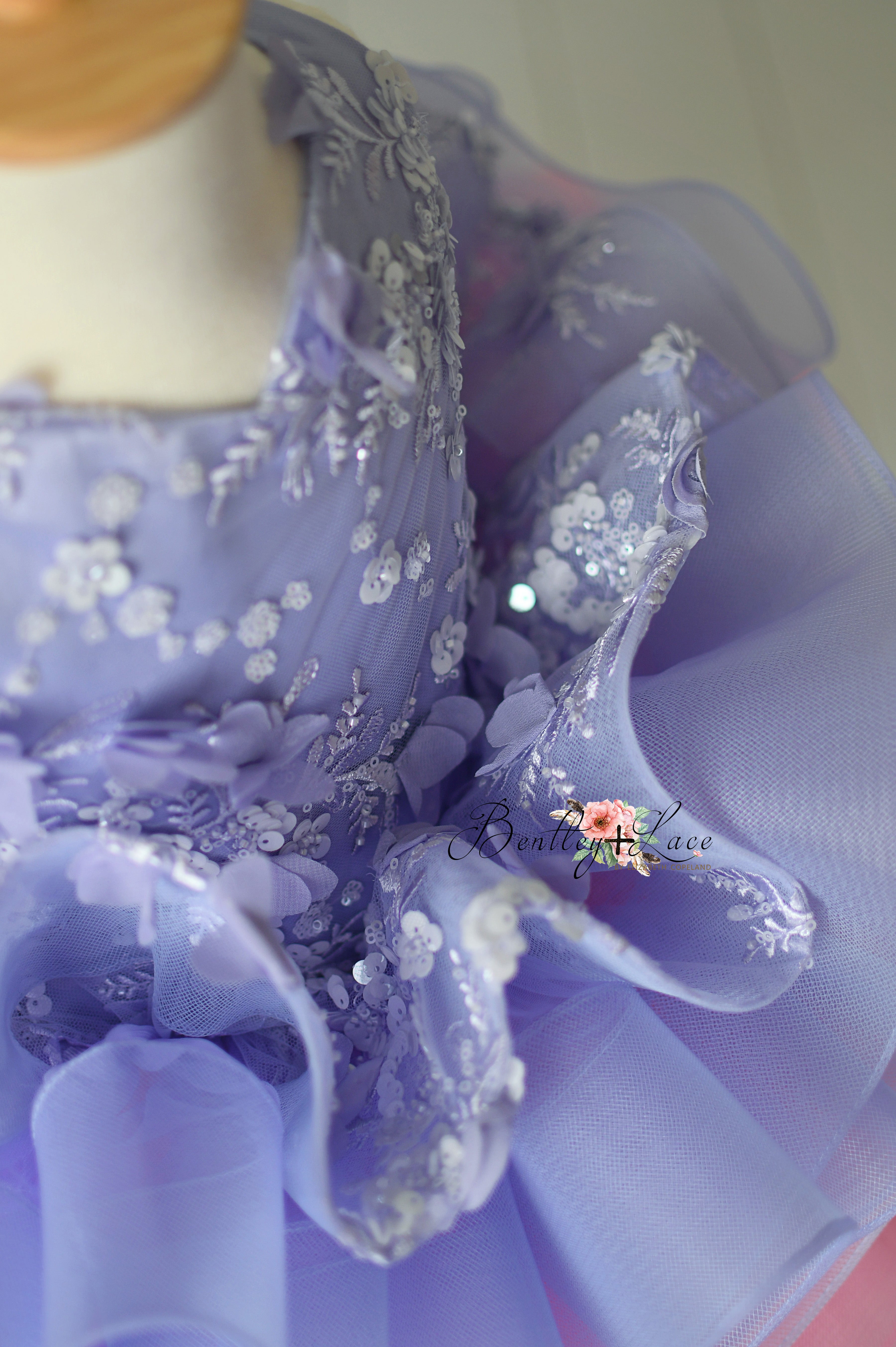 Detailed view of the soft, layered tulle skirt of the Lilac Enchantment petal-length dress in a beautiful lavender tone.