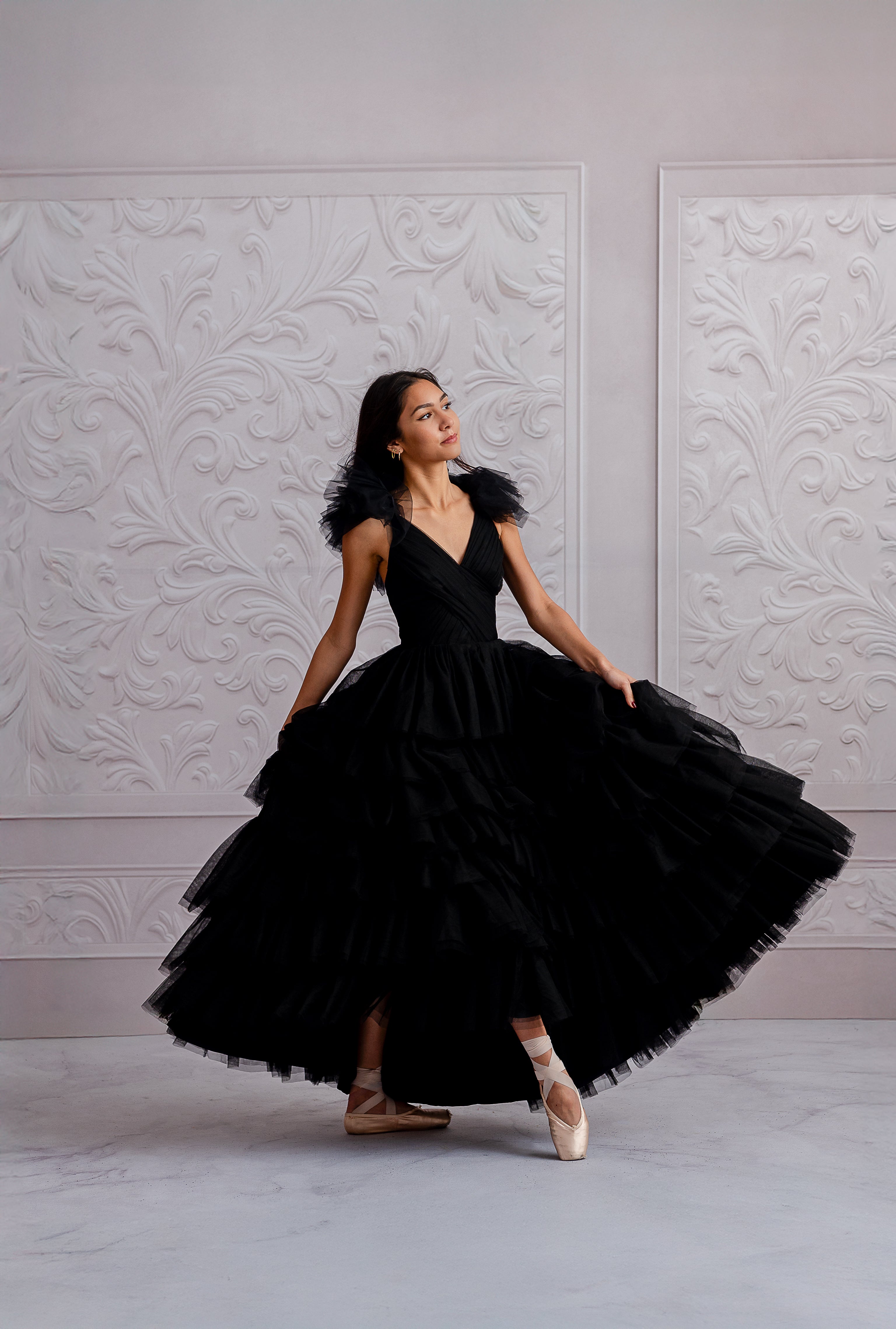 Elegant black tulle gown styled with ballet shoes in a photoshoot setting.