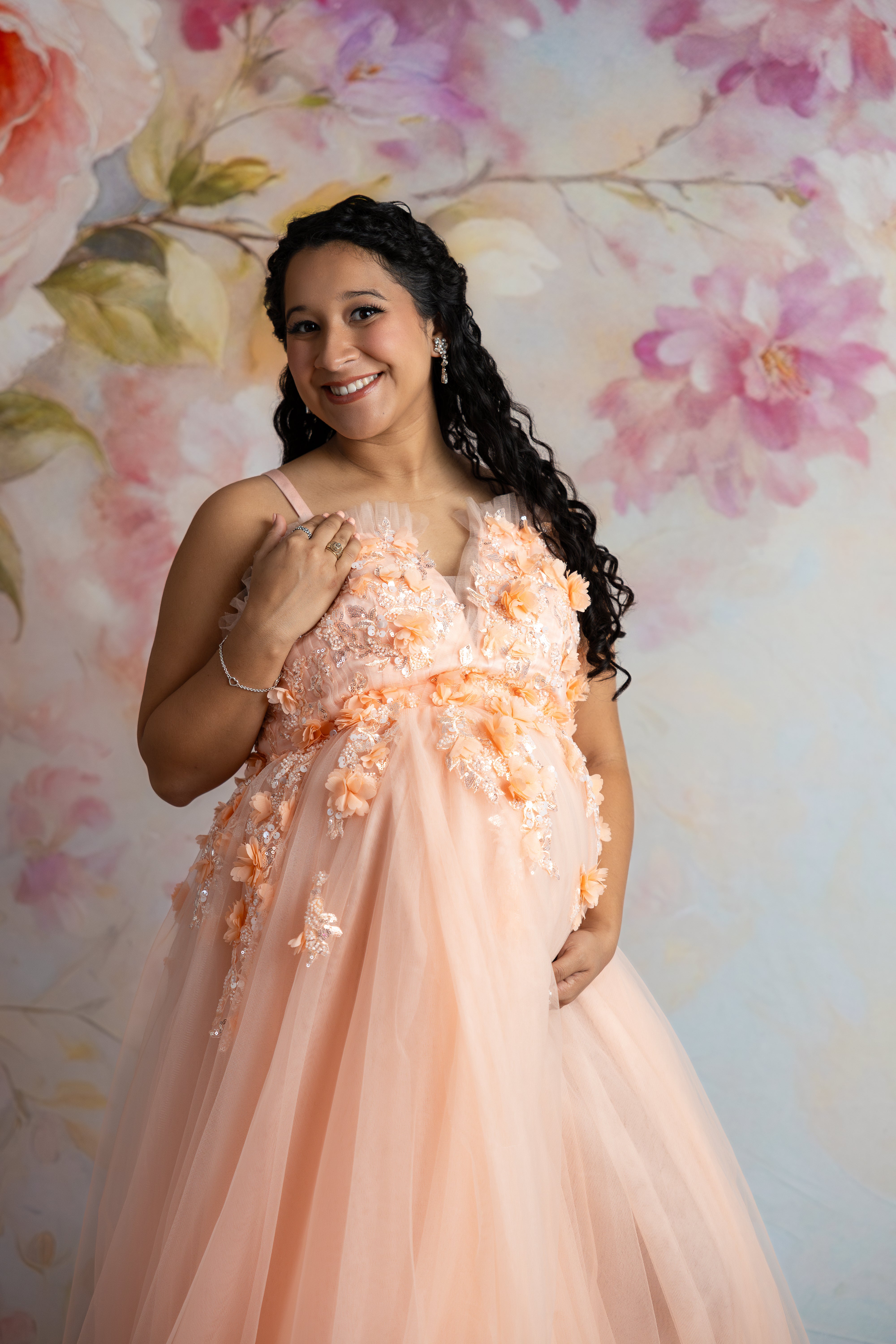 Peach gown with flowing tulle skirt and supportive corset, perfect for maternity photography.