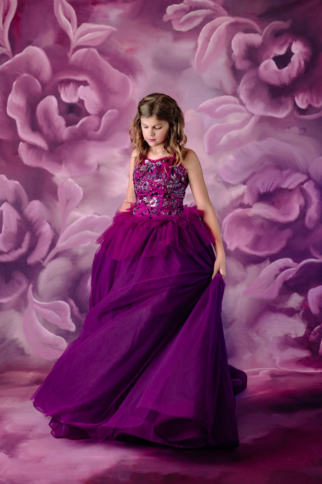 Girl wearing a luxurious purple tulle gown with a beaded top.