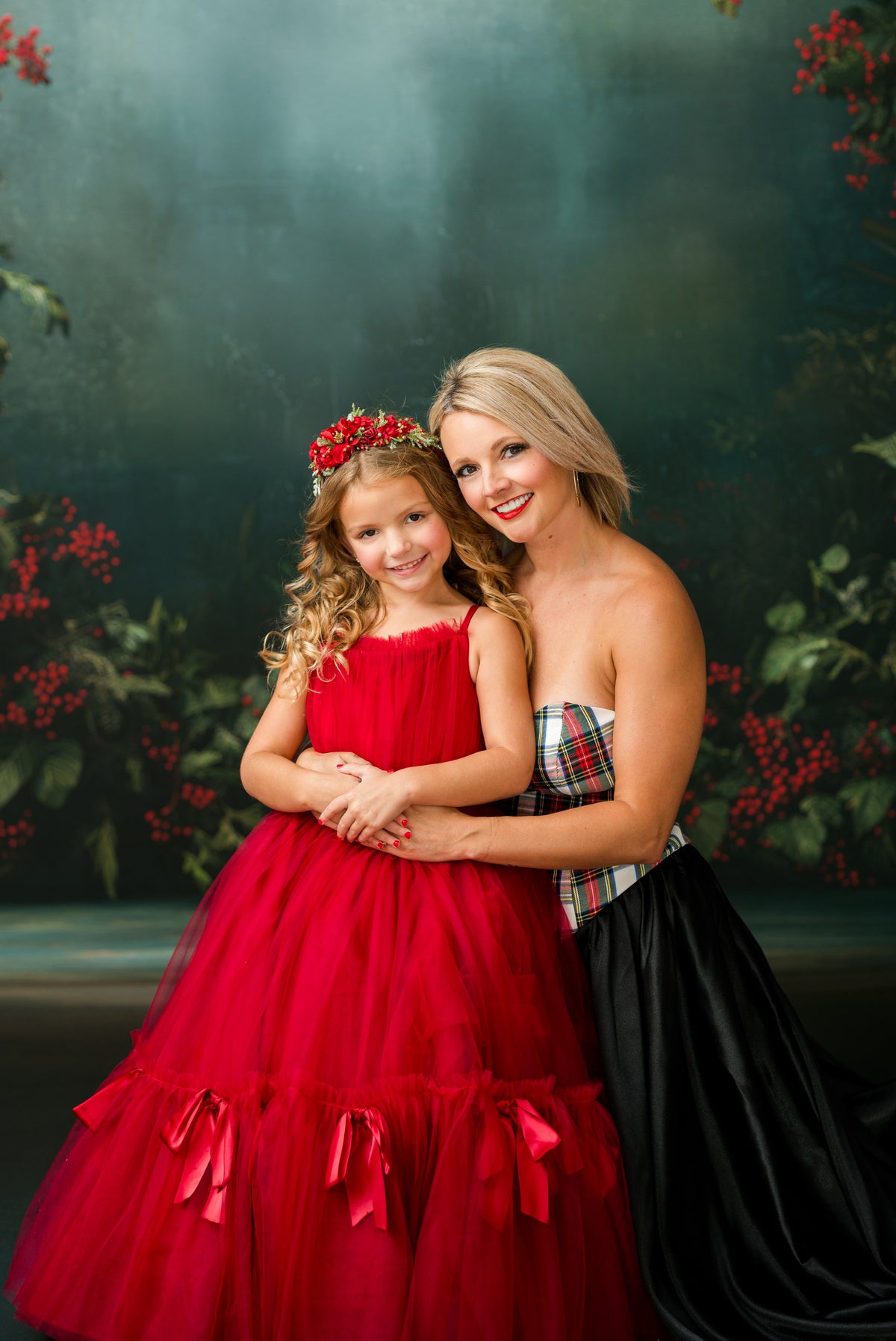 Christmas photography wardrobe featuring red satin gown and tartan corset overlay