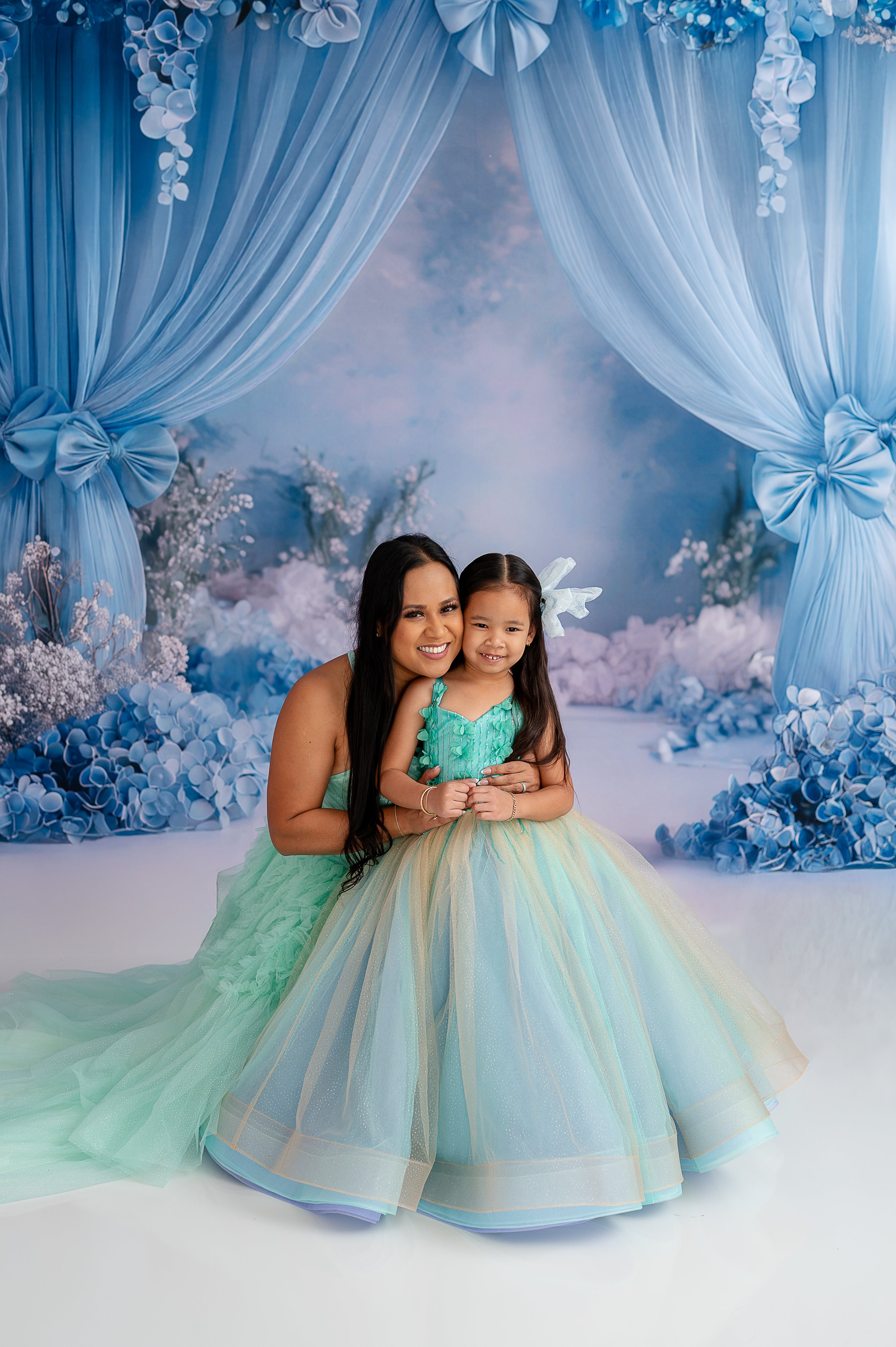 "Radiant mother and daughter in flowing tulle dresses, capturing a timeless family moment."