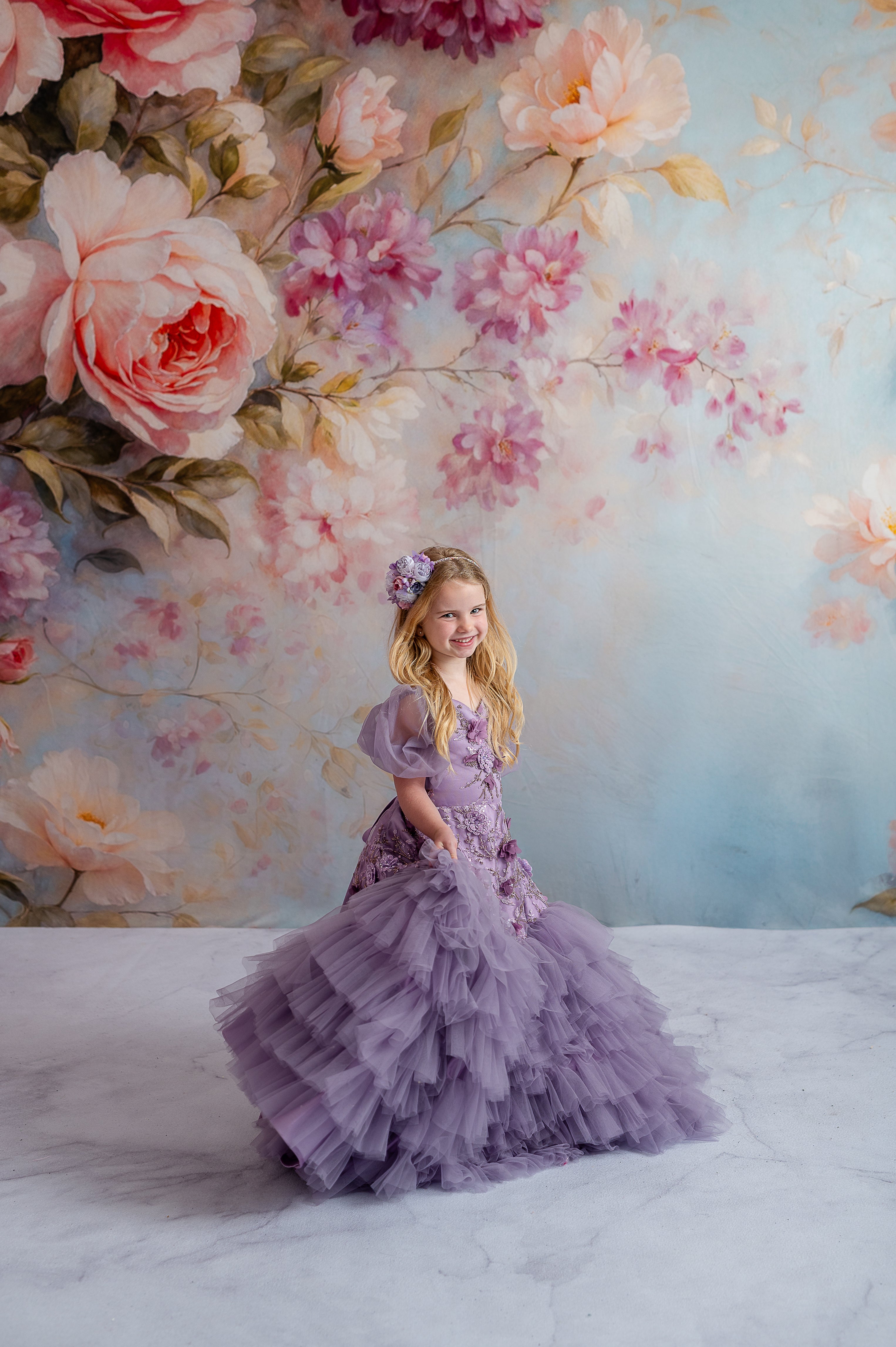 Child in lavender floor-length gown with detachable puff sleeves and floral appliqués.