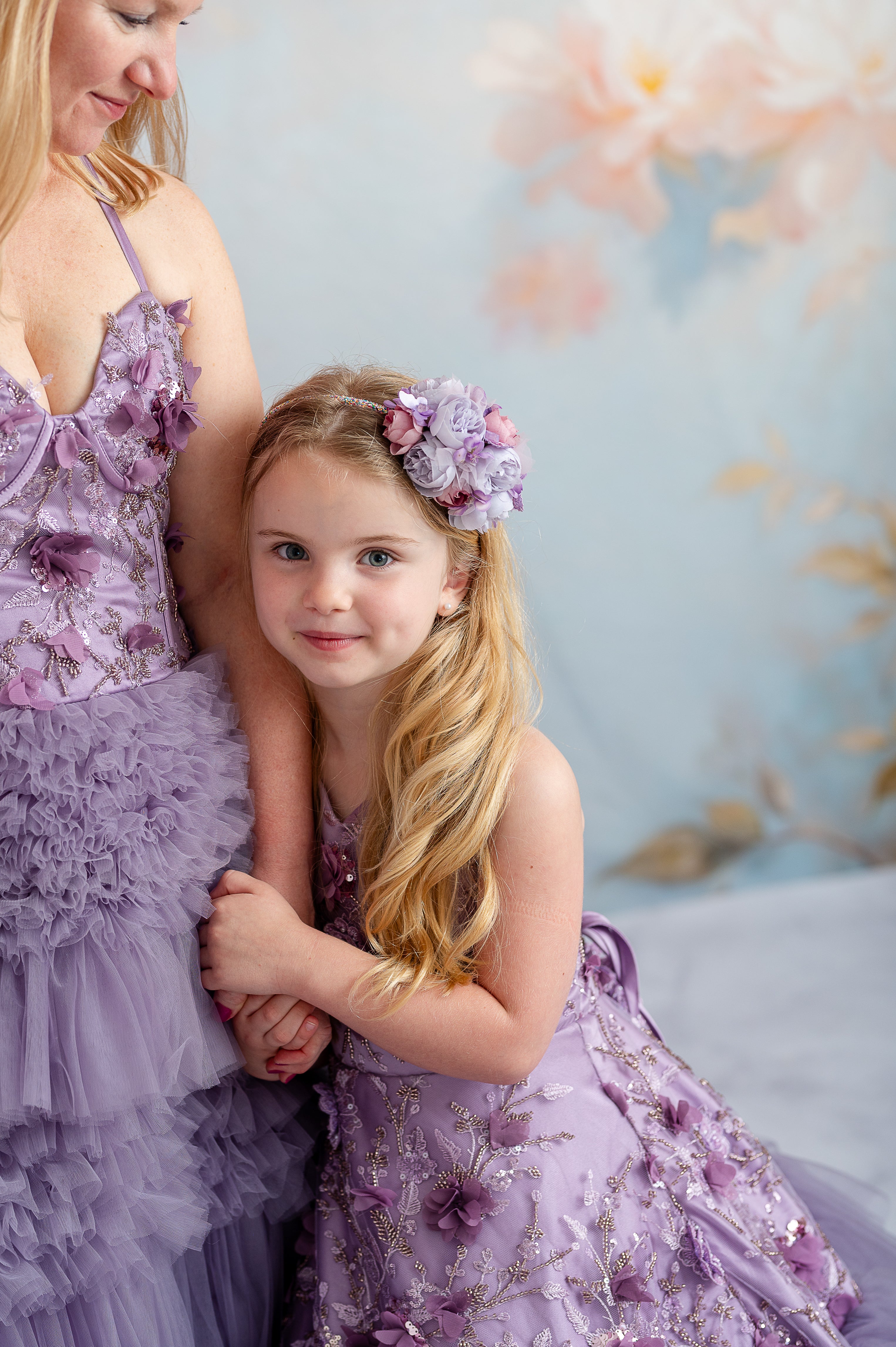 Bentley and Lace mommy and me session featuring coordinating floral lavender gowns under soft sunlight.