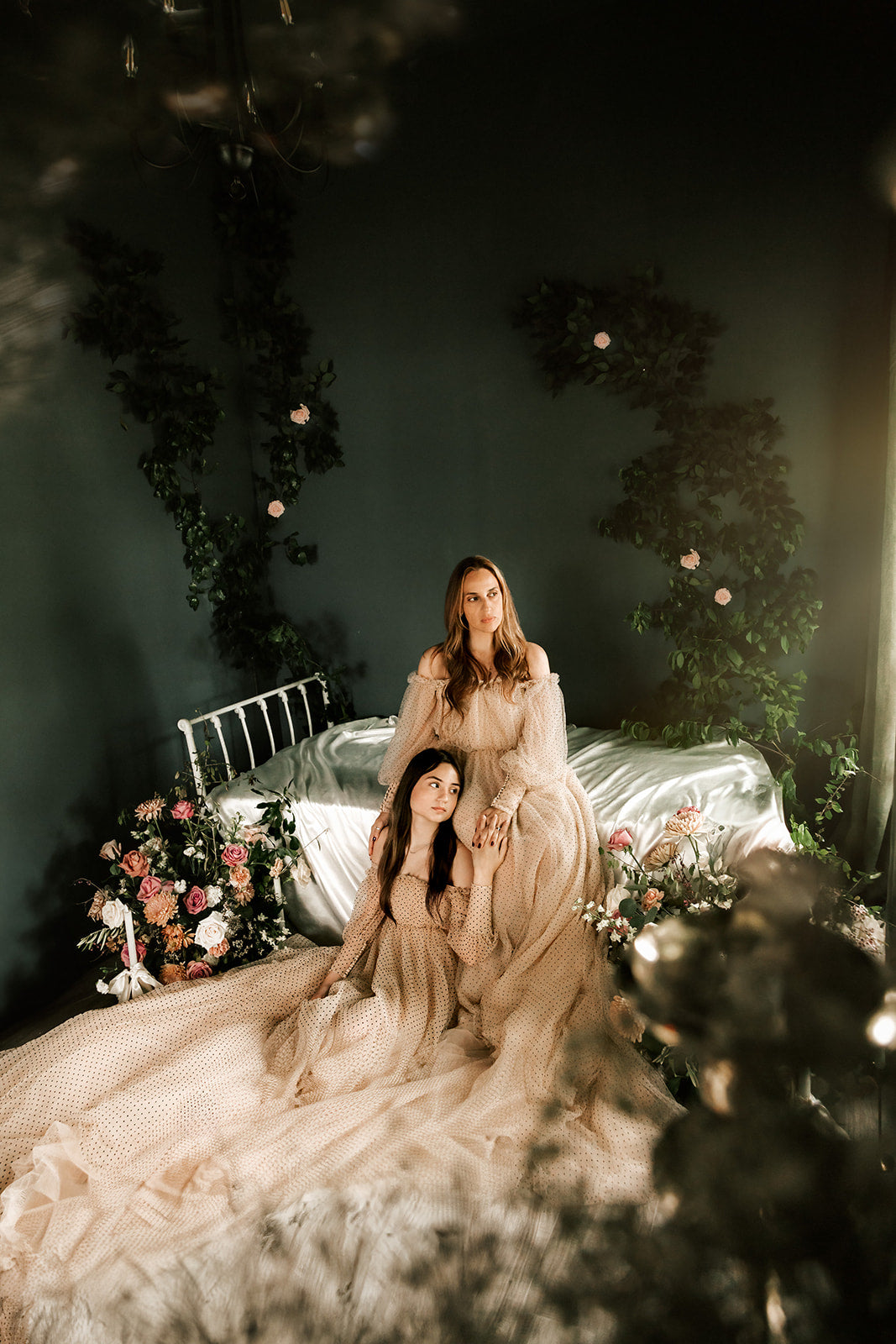 A stylish mother poses with her daughter, both wearing exquisite couture gowns for a special family photography session.