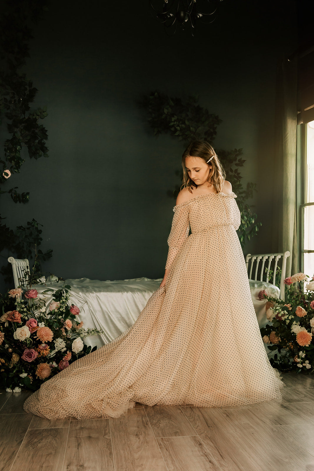 Young girl stands while wearing a beautiful swiss dot couture rental gown.