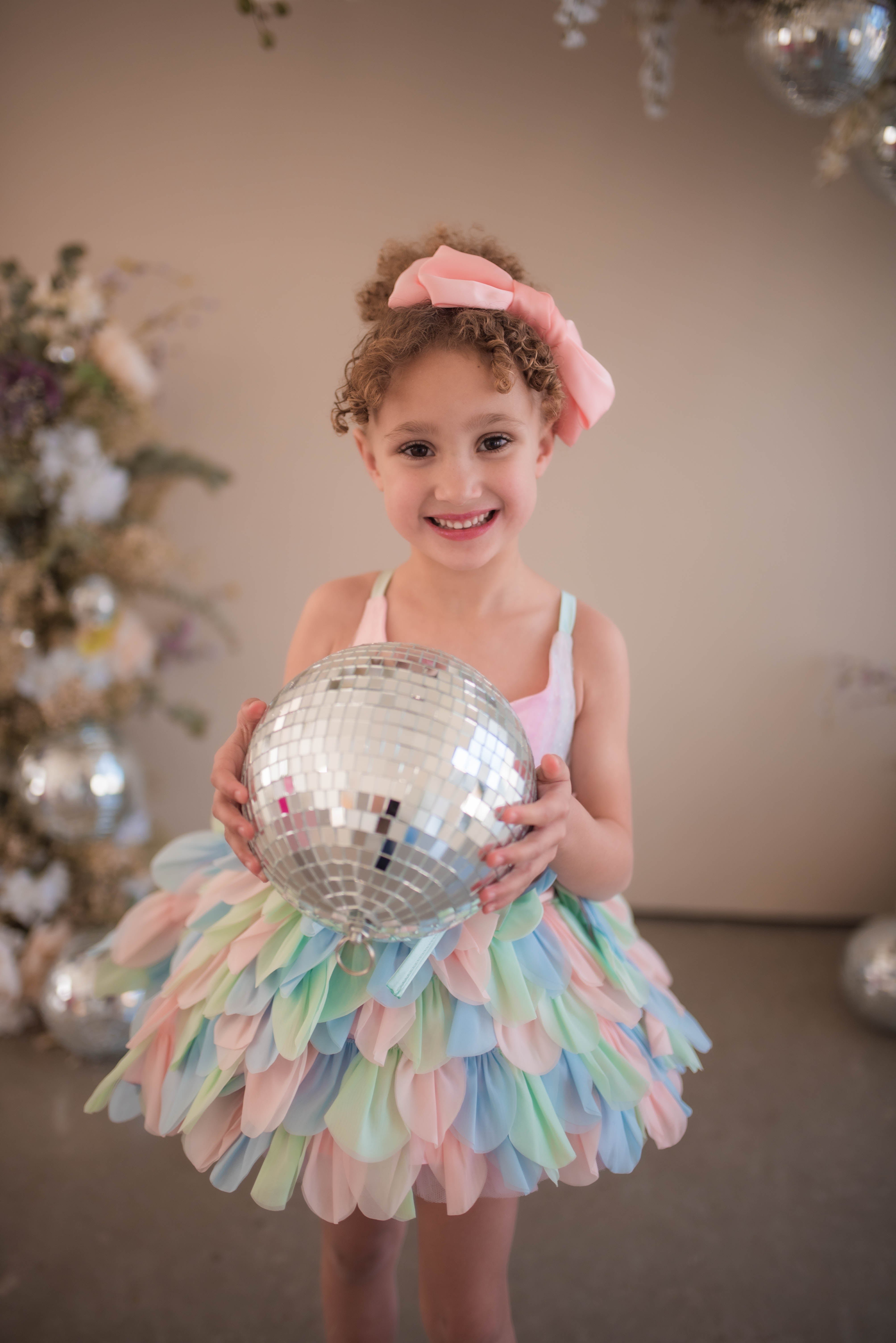 "Whimsical and artistic children’s fashion featuring a unique pastel petal outfit."