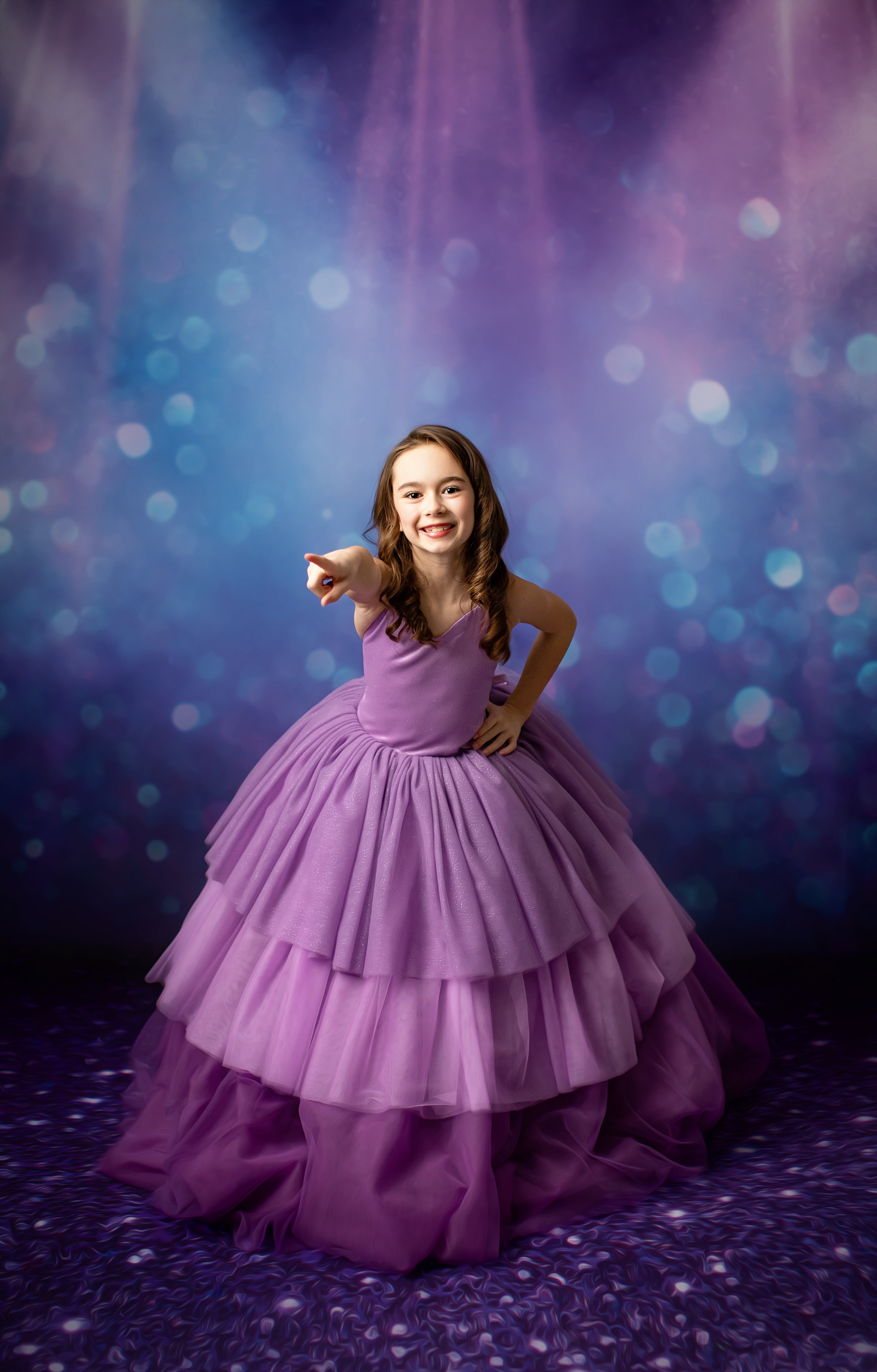 Little girl in a flowing lavender gown sings into a microphone, bathed in dramatic stage lighting.