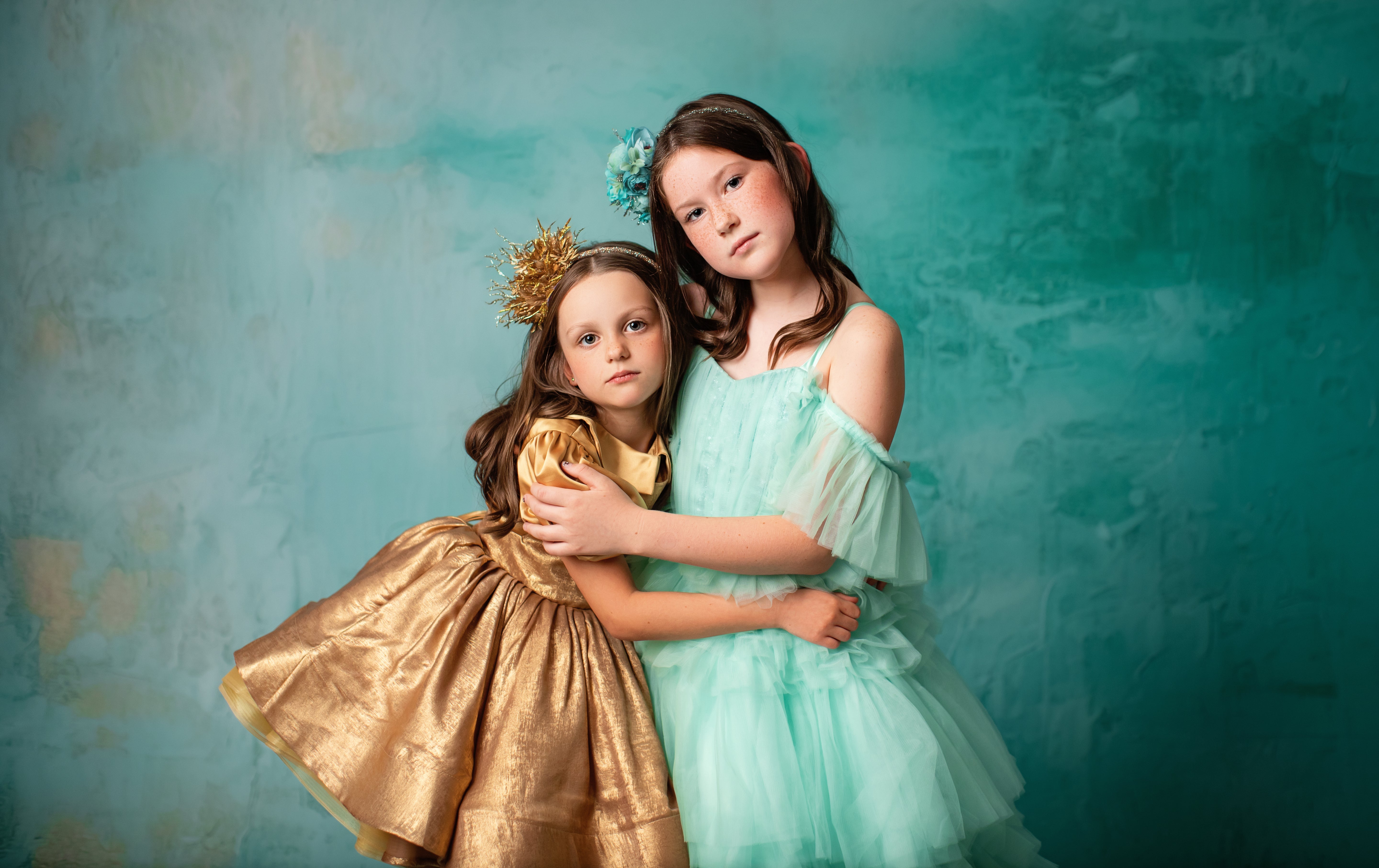 "Golden puff-sleeve dress with a full skirt and matching crown, worn by a smiling girl."
