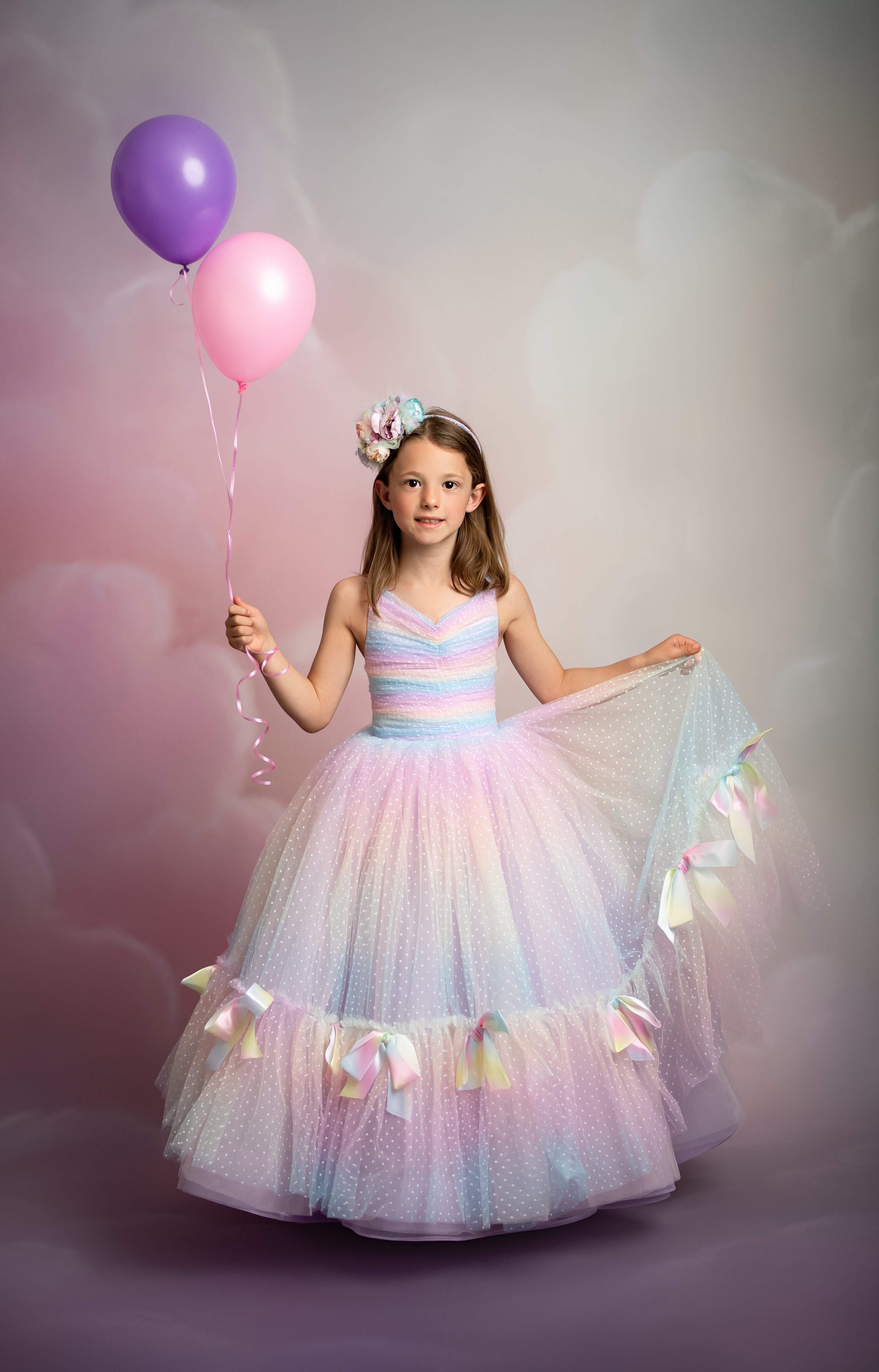 "Little girl twirling in the Addison Couture Gown with embroidered lace and soft tulle layers"