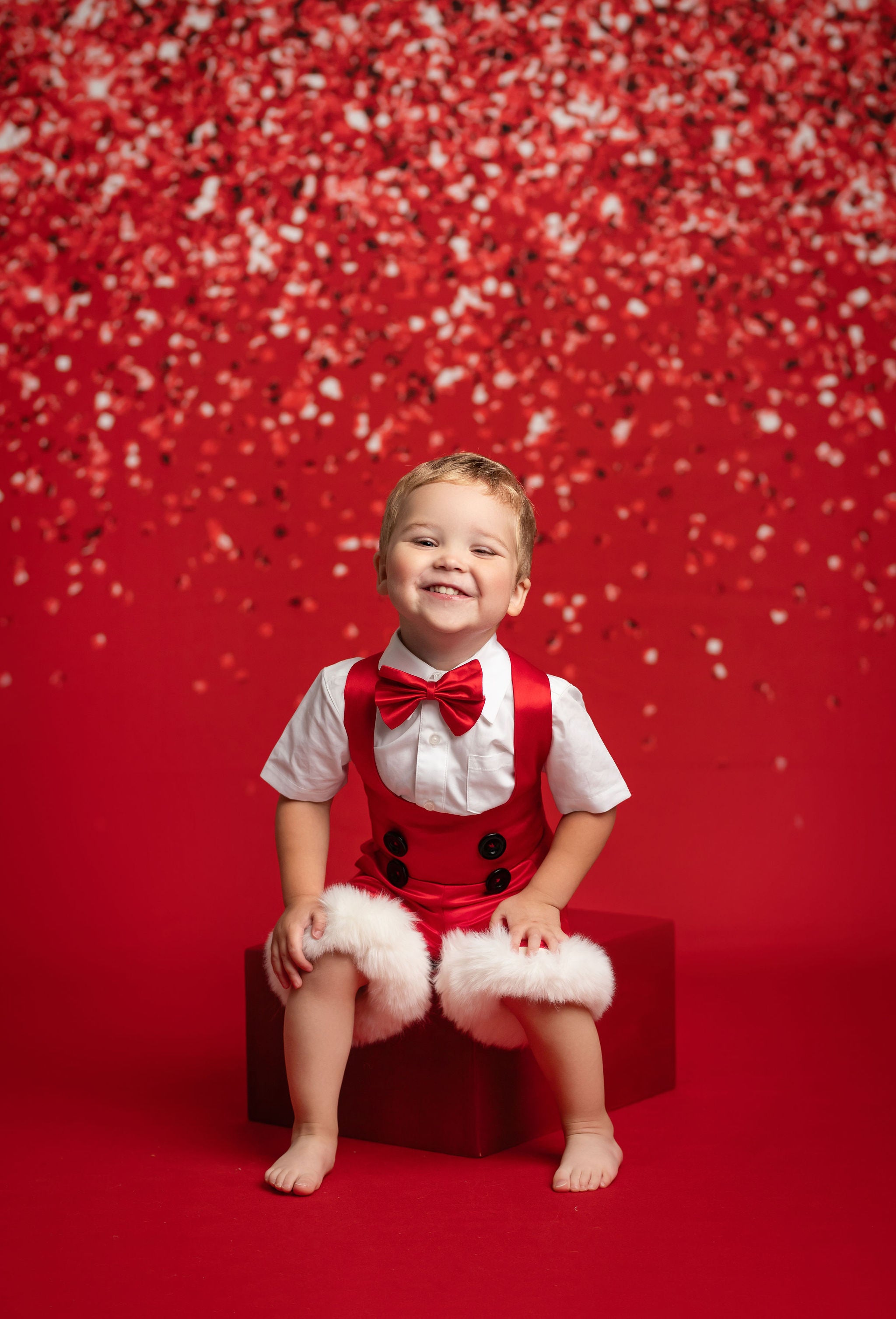 Child in a festive outfit with a red background
