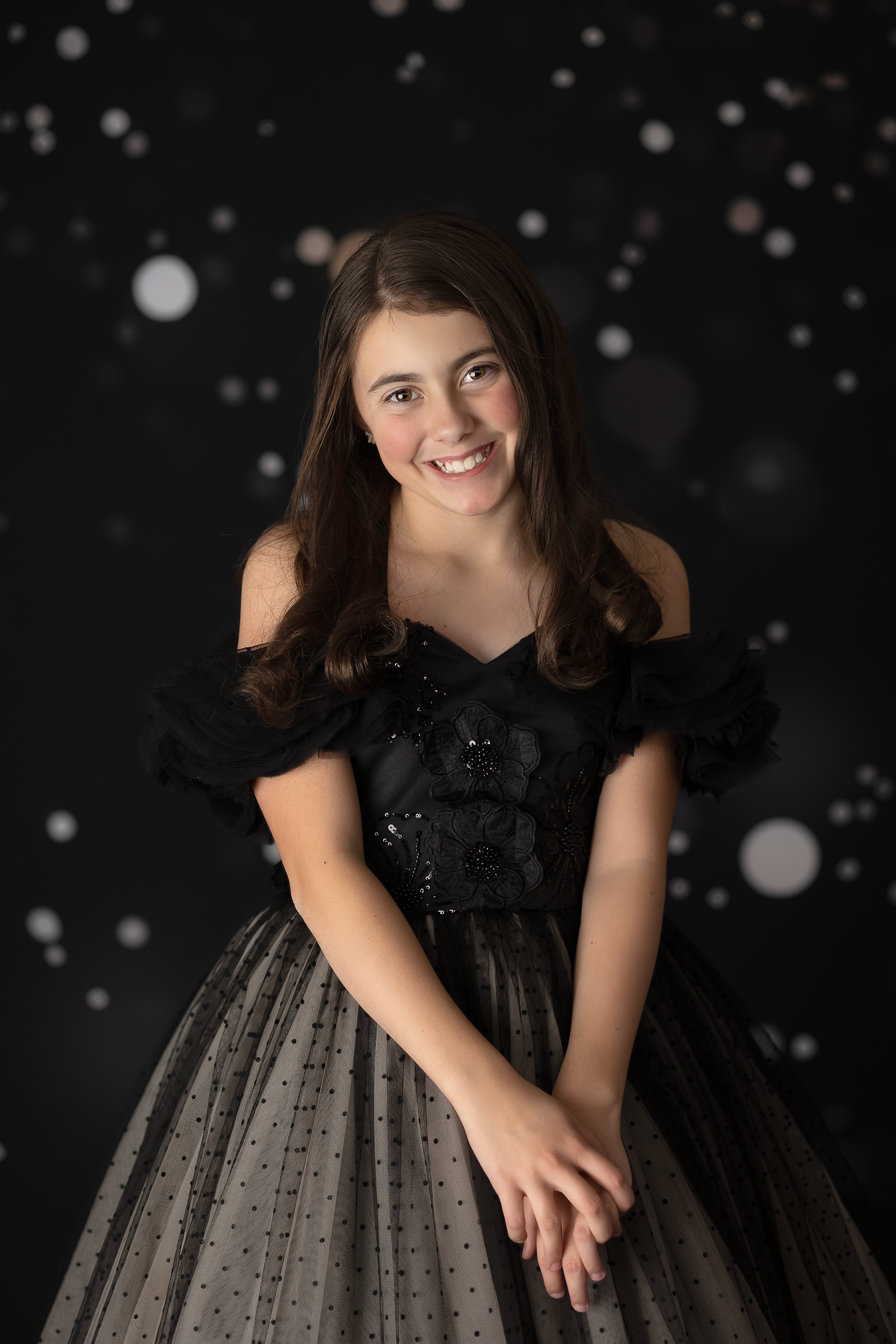 Sophisticated black dress featuring intricate lace details, shimmering sequins, and off-shoulder ruffles.