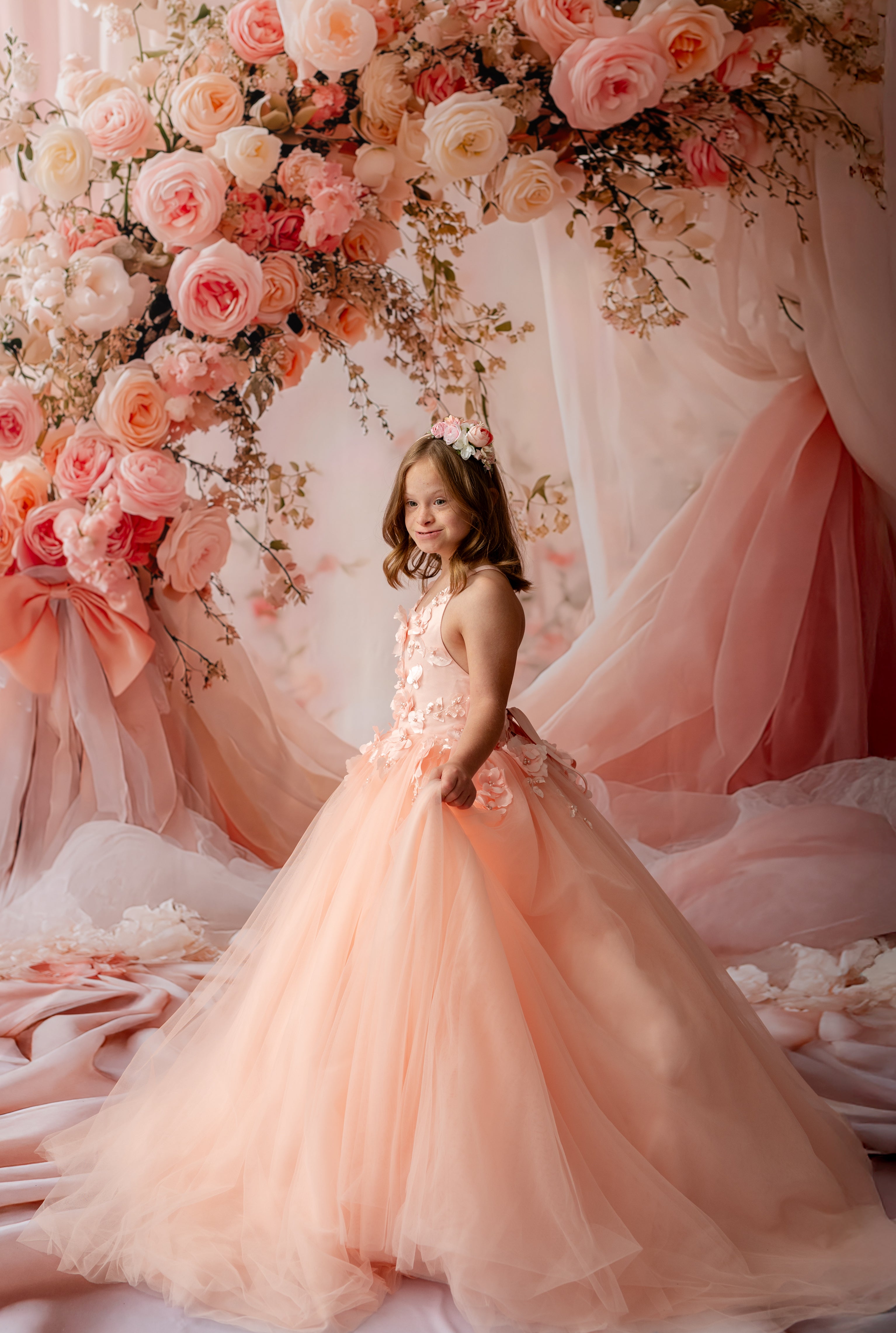 "Girl in couture flower dress with peach layers and off-shoulder detail"