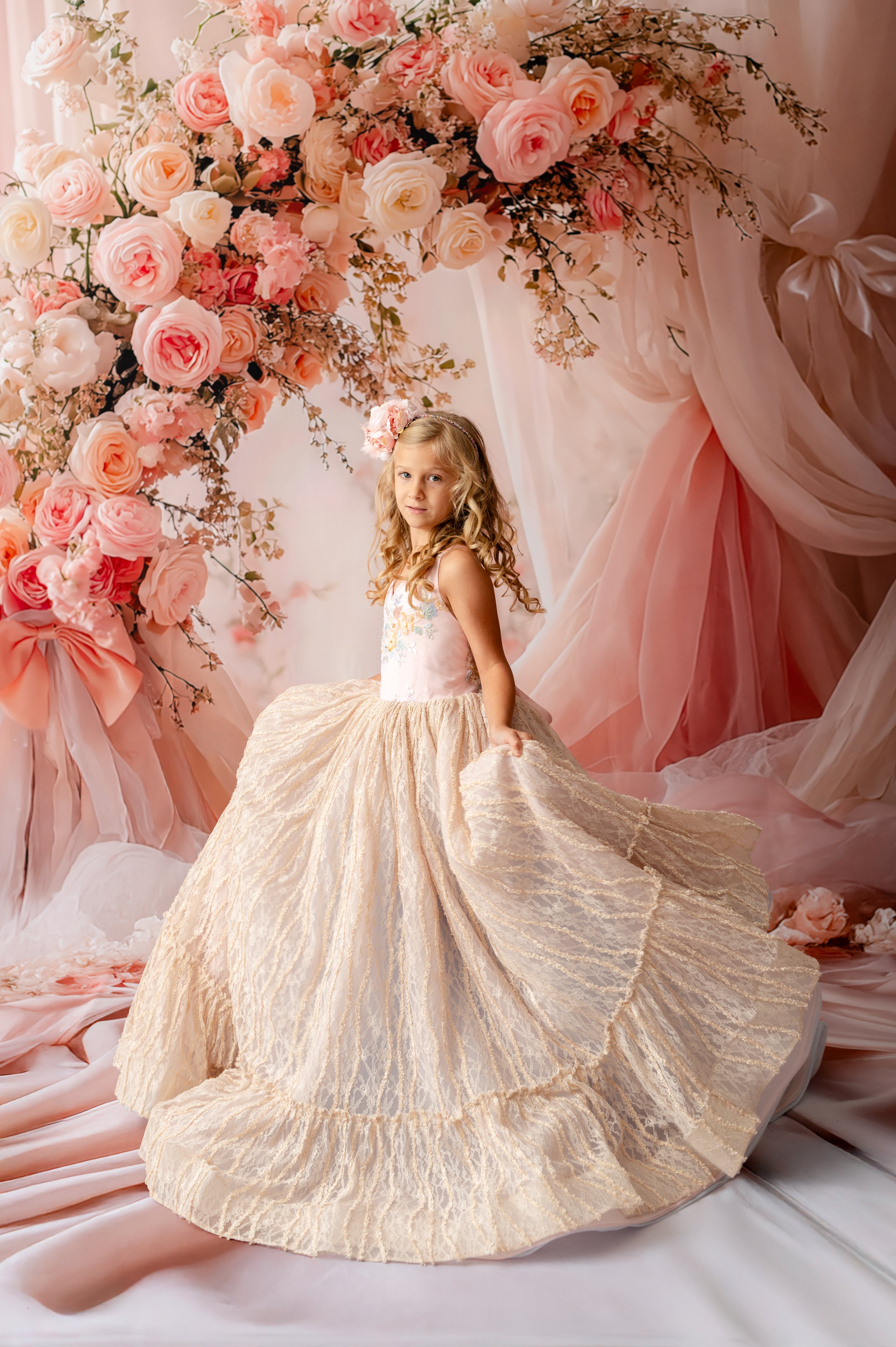"Girl wearing Garden of Dreams floor-length couture dress in blush and champagne lace"