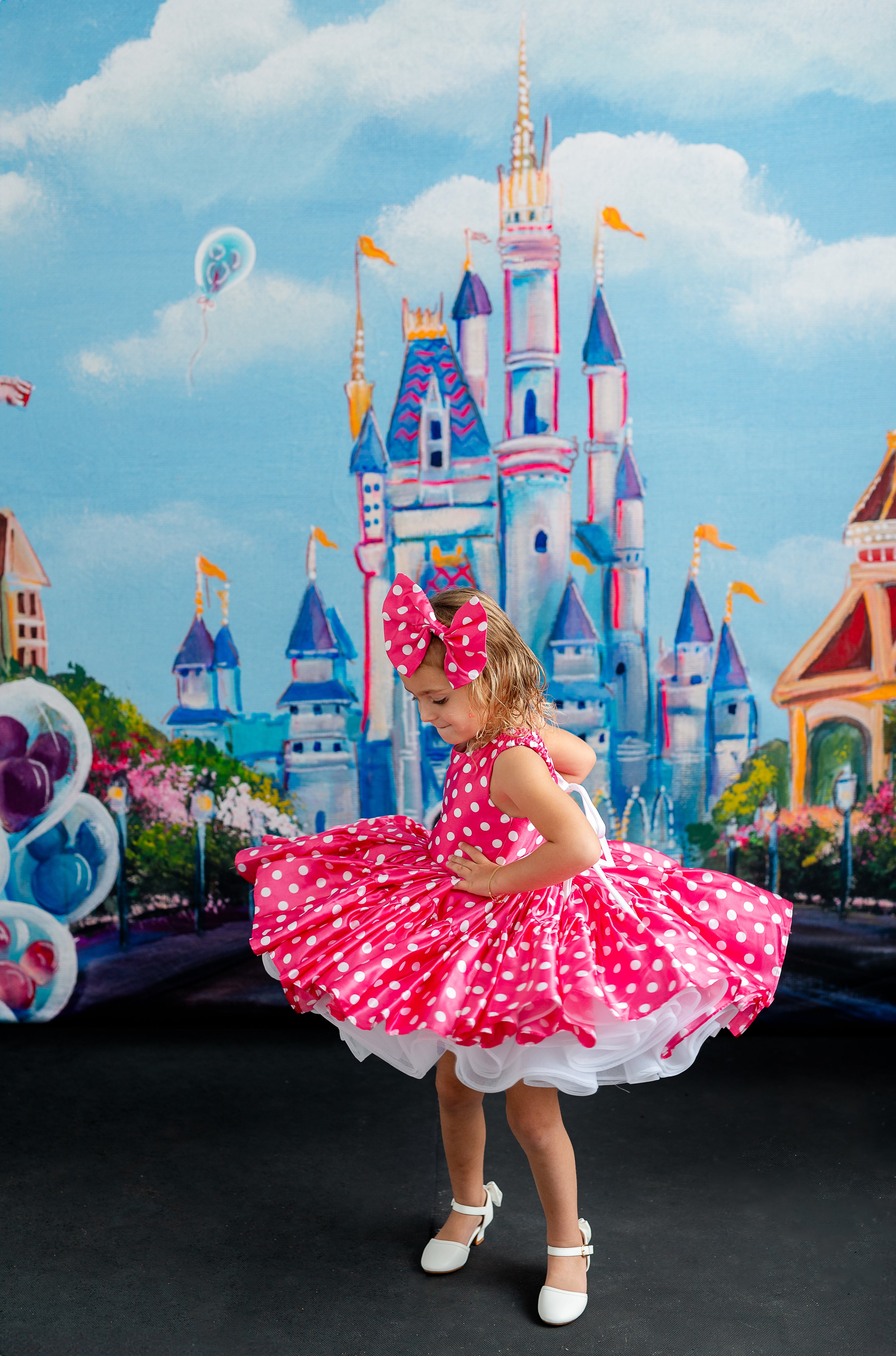 "Minnie Mouse-inspired pink dress with white polka dots, featuring a playful bow and puffed sleeves for a whimsical touch."